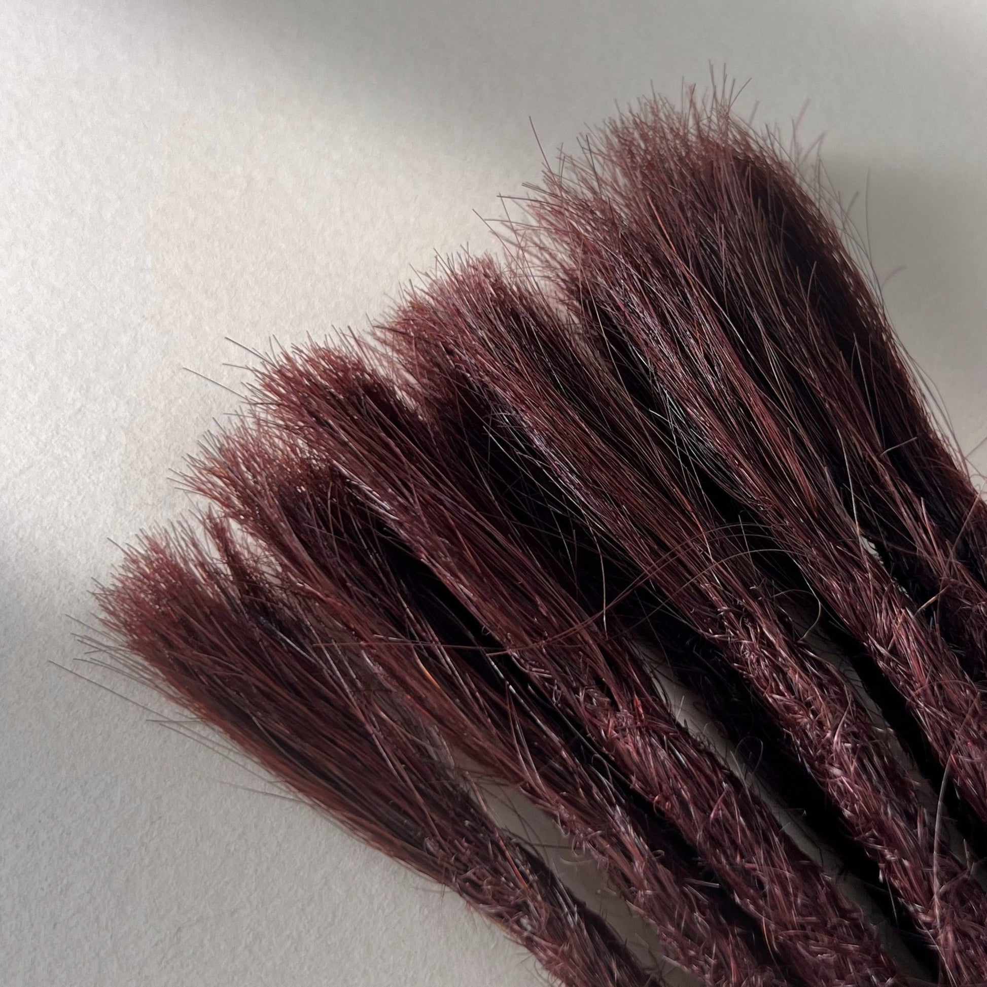 Connection point of permanent straight loc extensions in Deep Crimson Red.