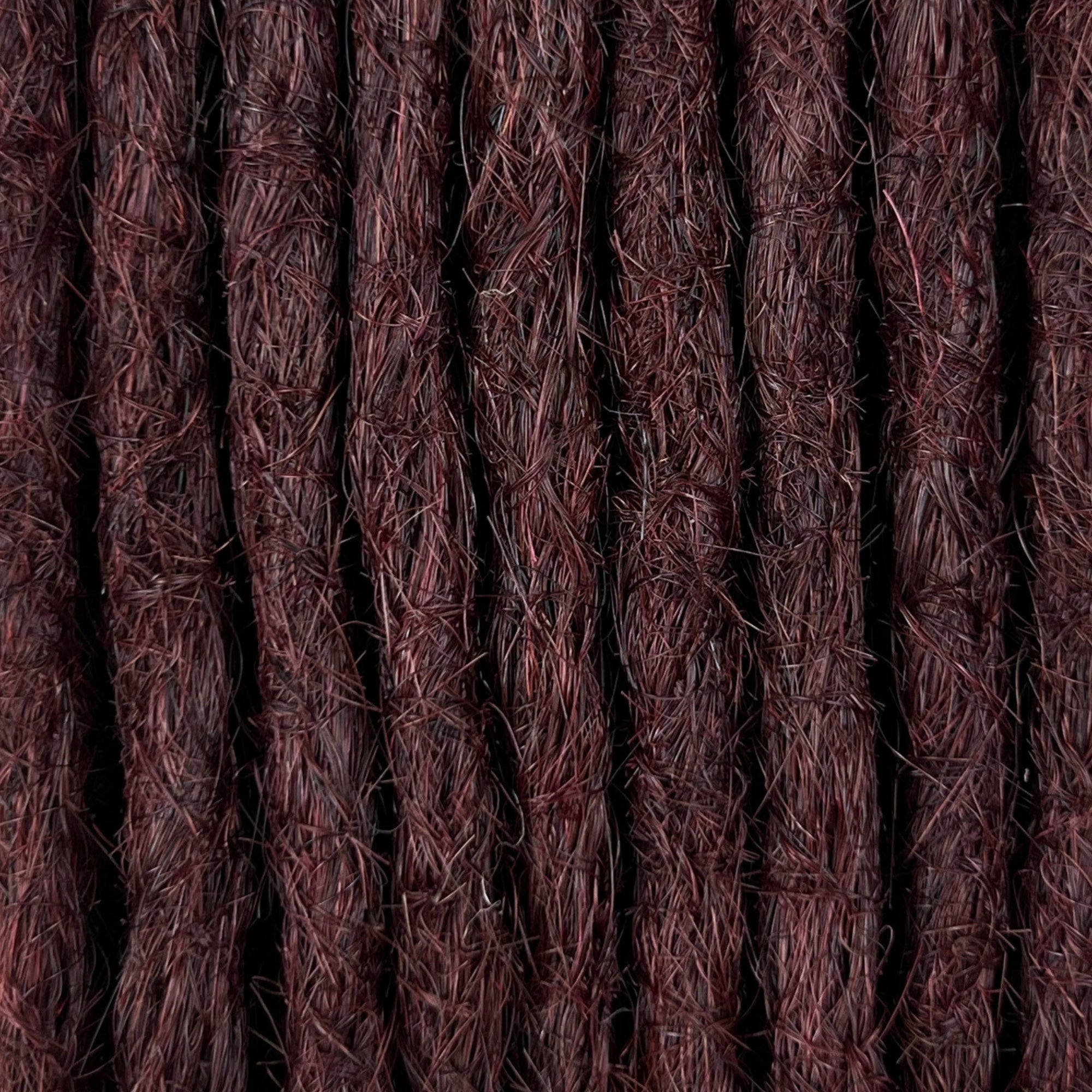 Close-up of straight loc extensions in Deep Crimson Red, showing the texture and color.