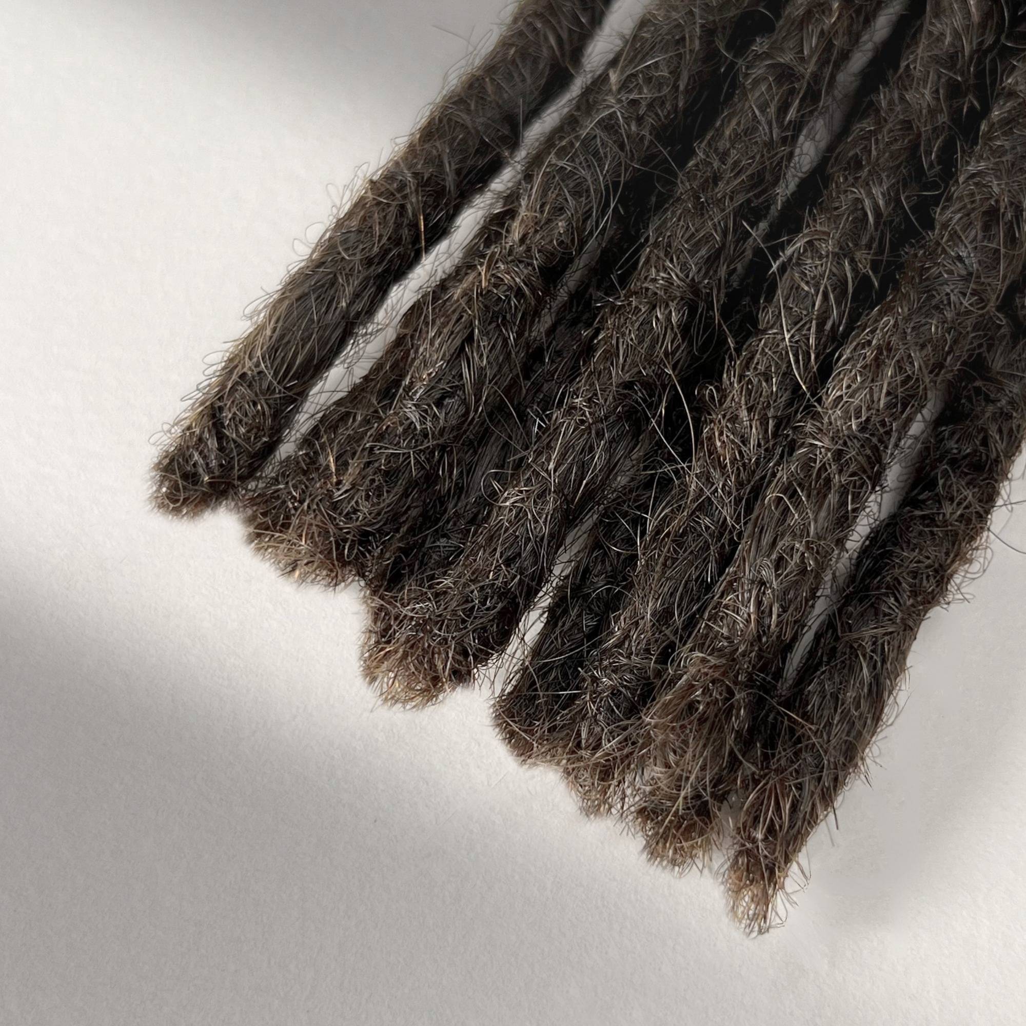 Tip detail of straight loc extensions with blunt ends in Dark Wenge Brown.