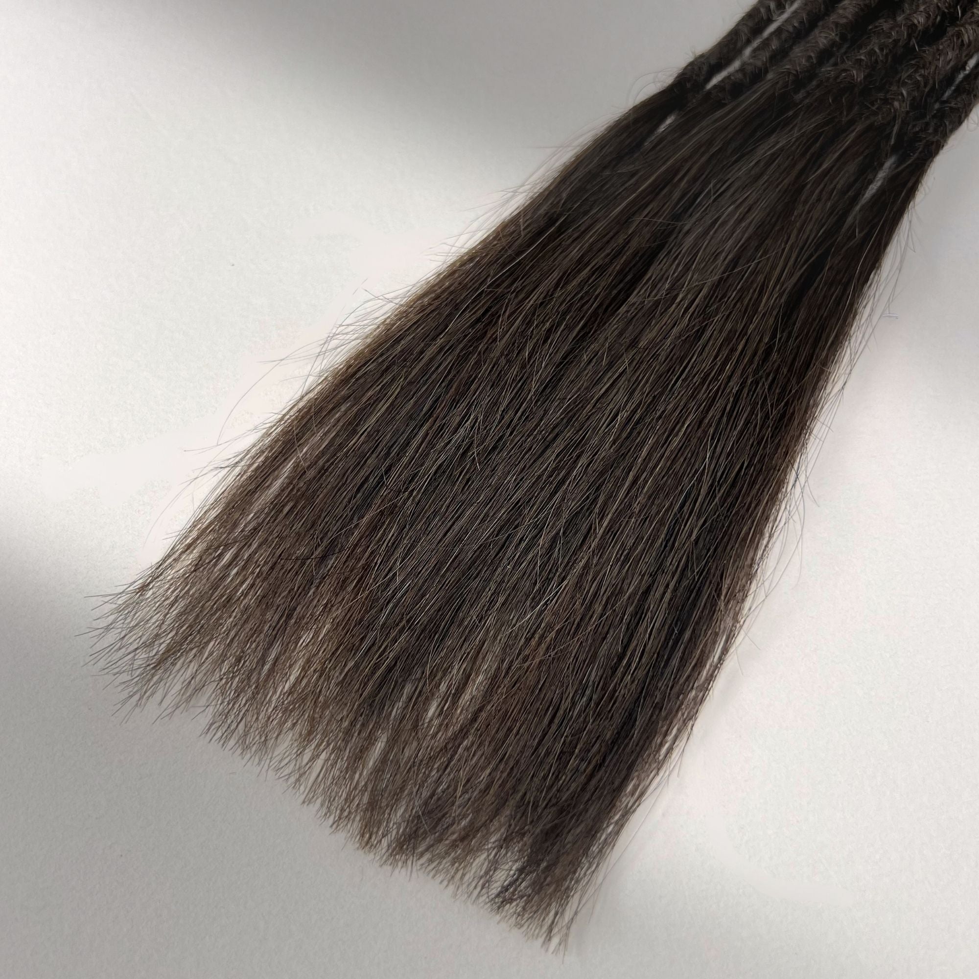 Tip detail of straight loc extensions with long loose ends in Dark Wenge Brown.