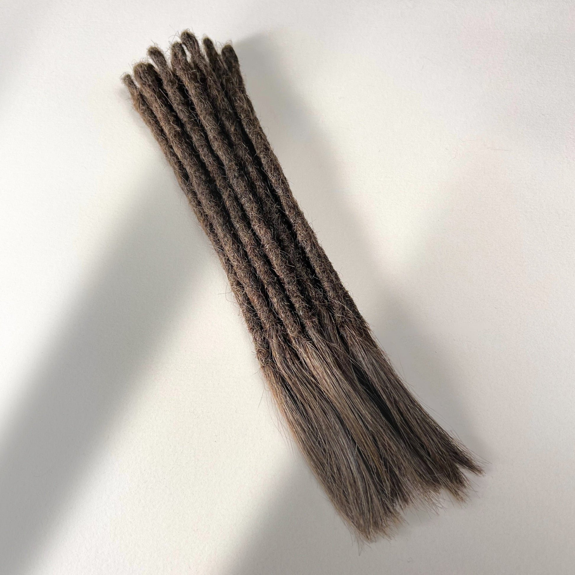 Full view of temporary single-ended straight loc extensions with open ends in Dark Wenge Brown.