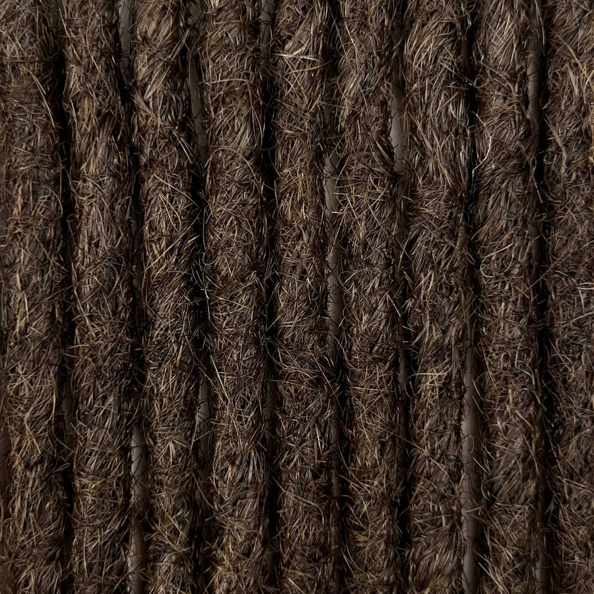Close-up of straight loc extensions in Dark Wenge Brown, showing the texture and color.