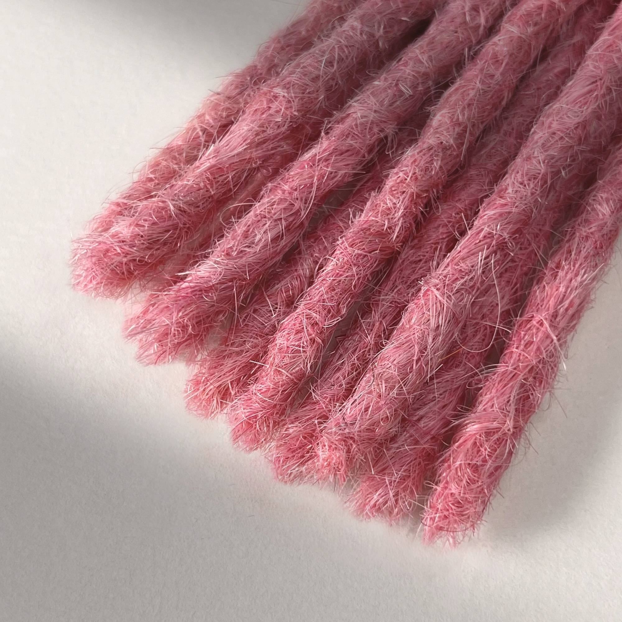 Tip detail of straight loc extensions with blunt ends in Bubblegum Pink.