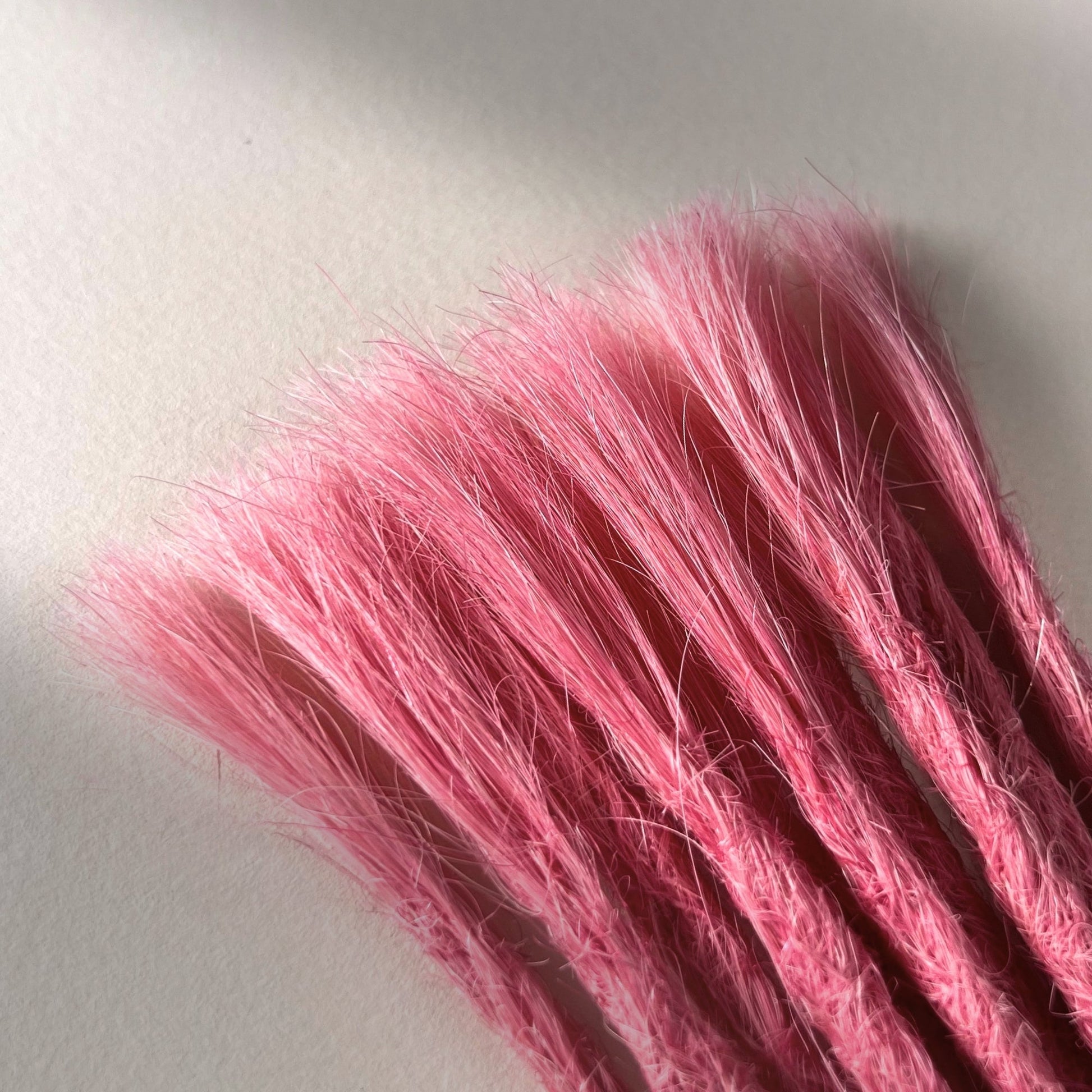 Connection point of permanent straight loc extensions in Bubblegum Pink.