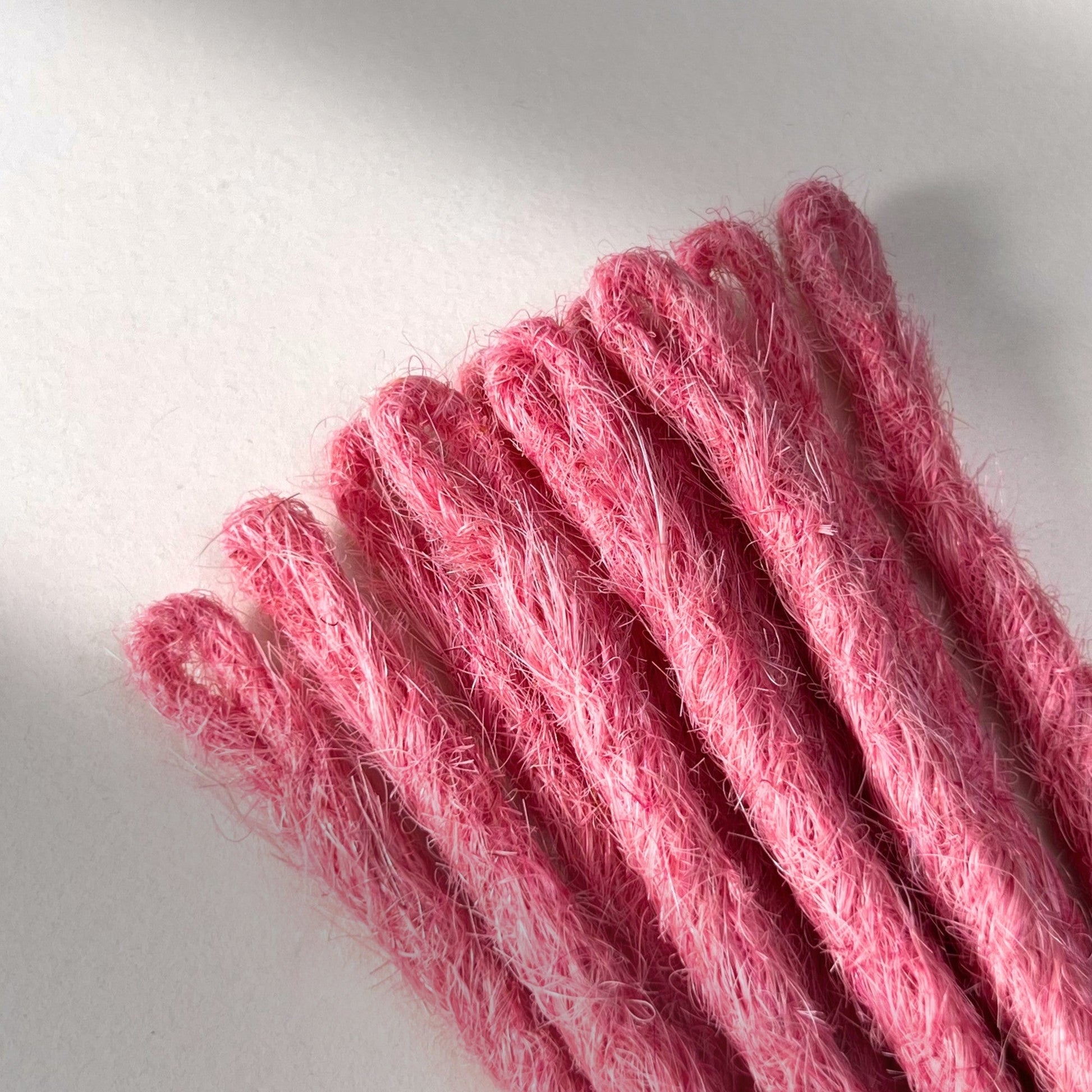 Loop detail of temporary single-ended straight loc extensions in Bubblegum Pink.
