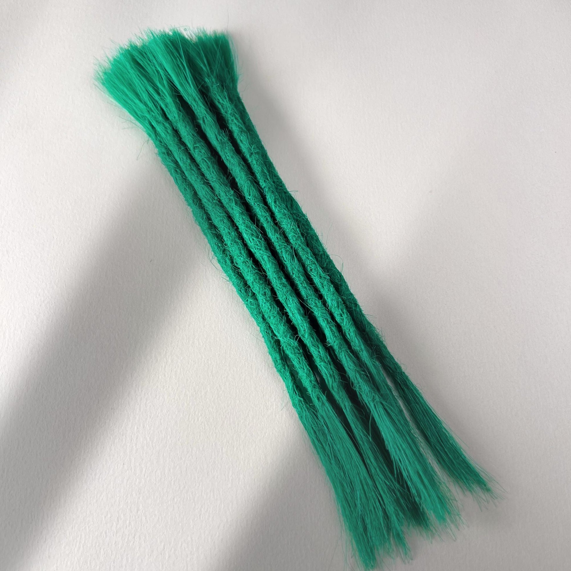 Full view of permanent straight loc extensions with open ends in Emerald Green.