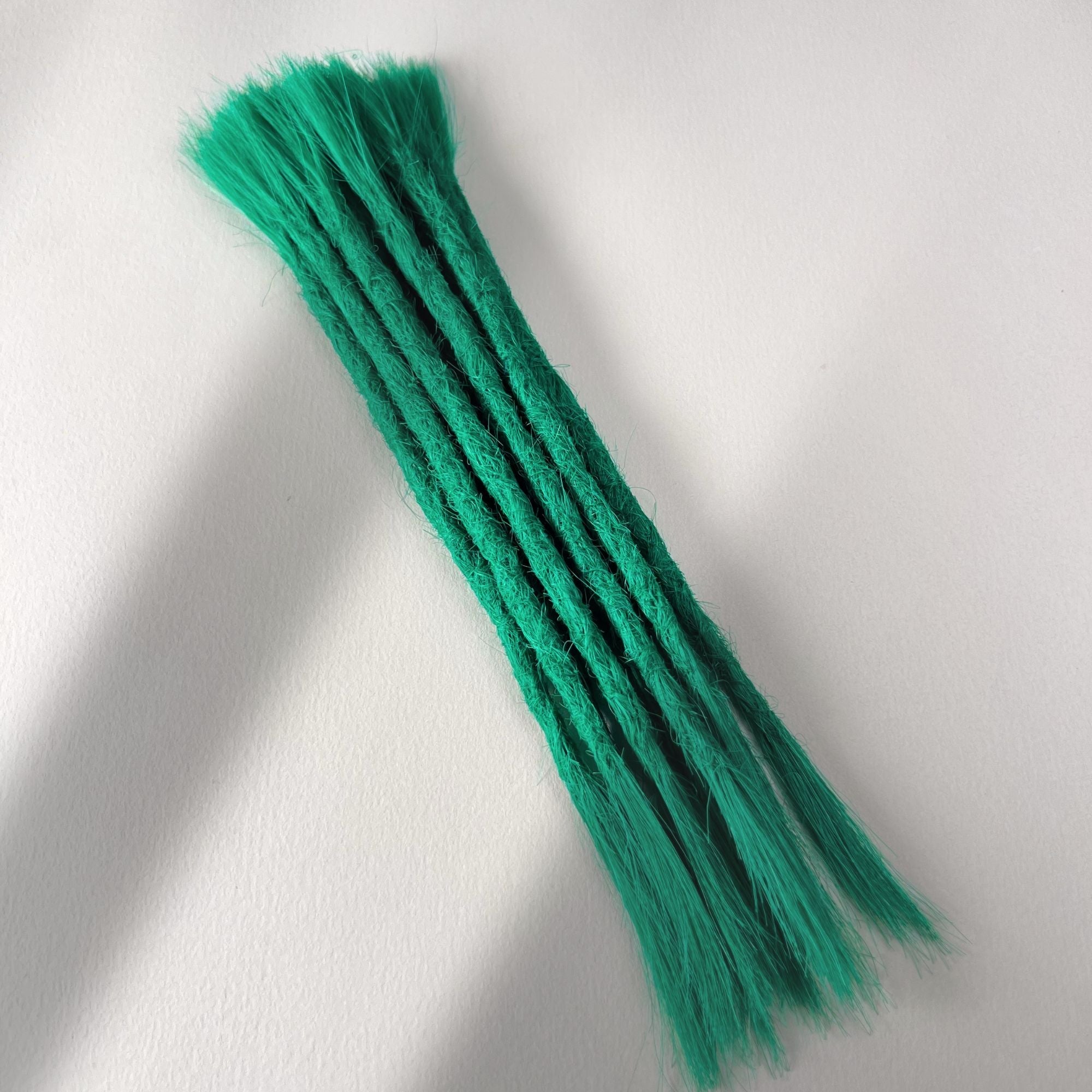 Full view of permanent straight loc extensions with open ends in Emerald Green.