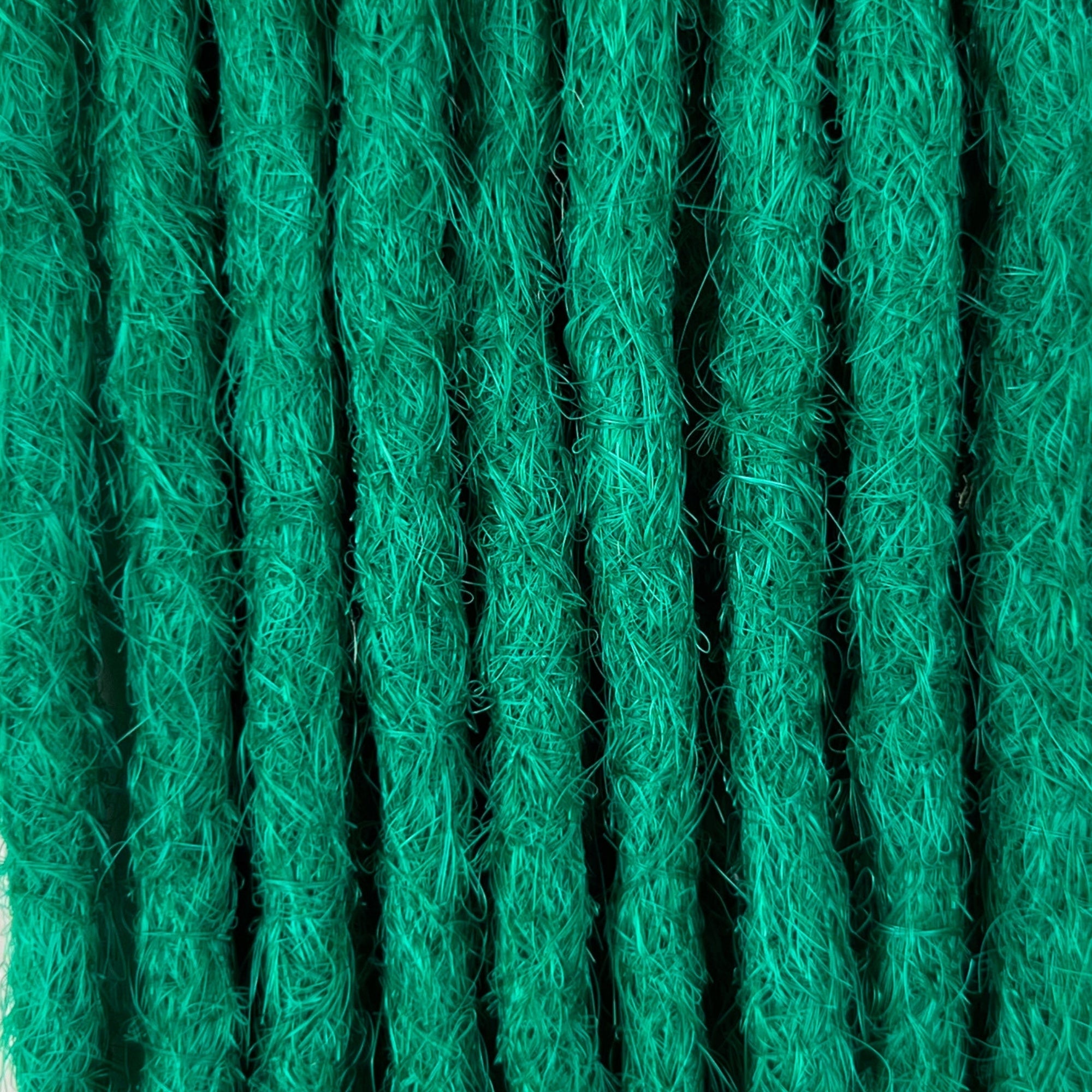Close-up of straight loc extensions in Emerald Green, showing the texture and color.