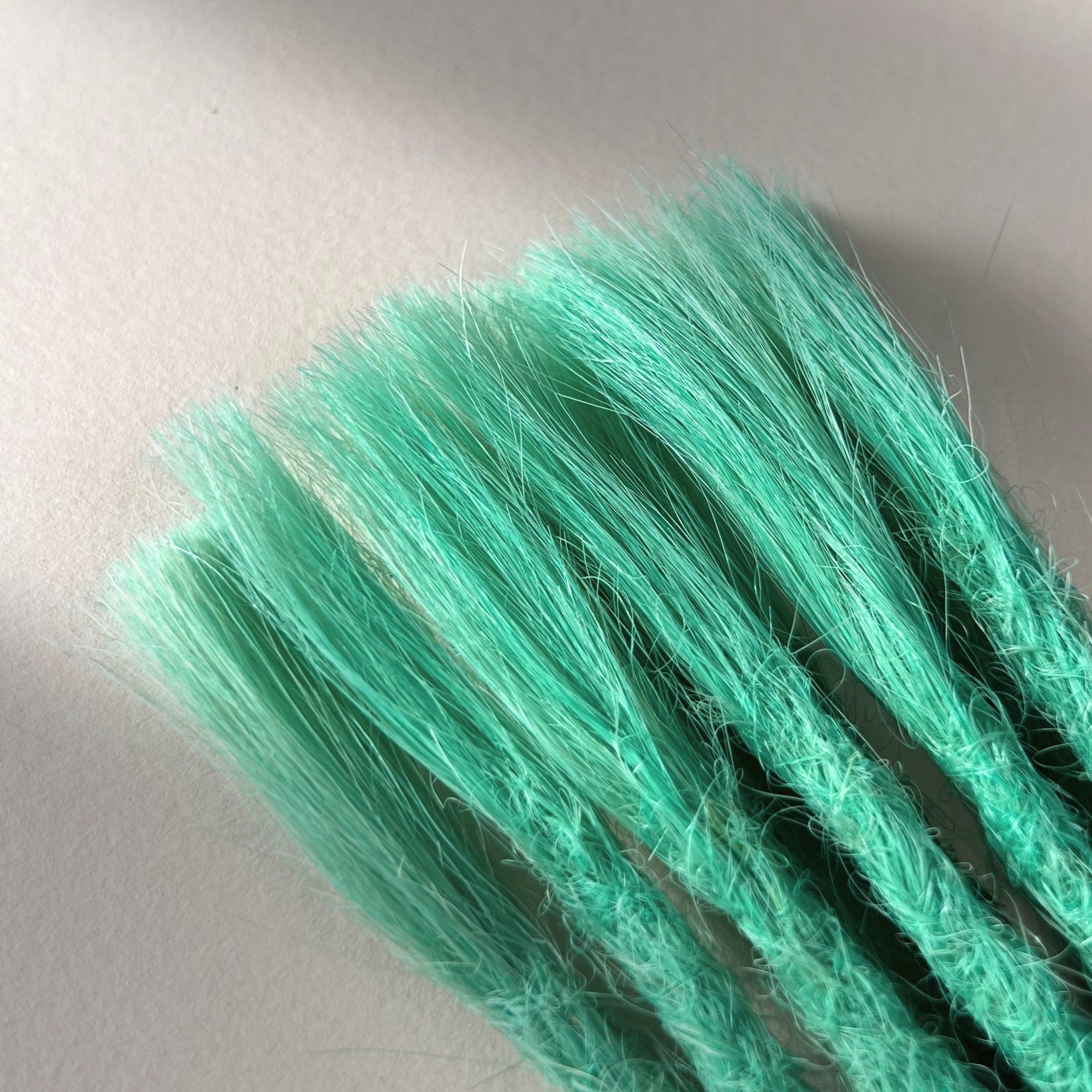Connection point of permanent straight loc extensions in Pastel Emerald Green.