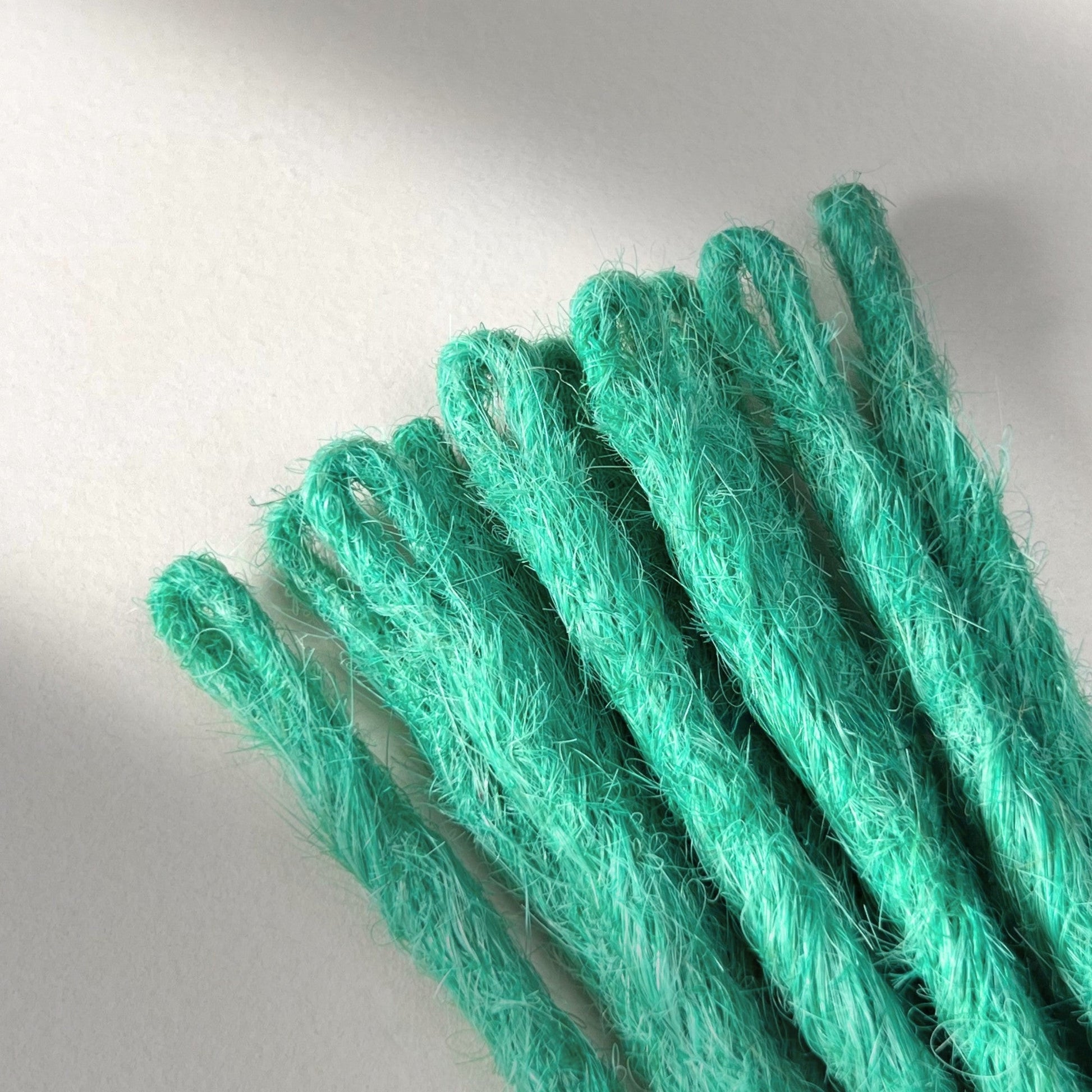 Loop detail of temporary single-ended straight loc extensions in Pastel Emerald Green.