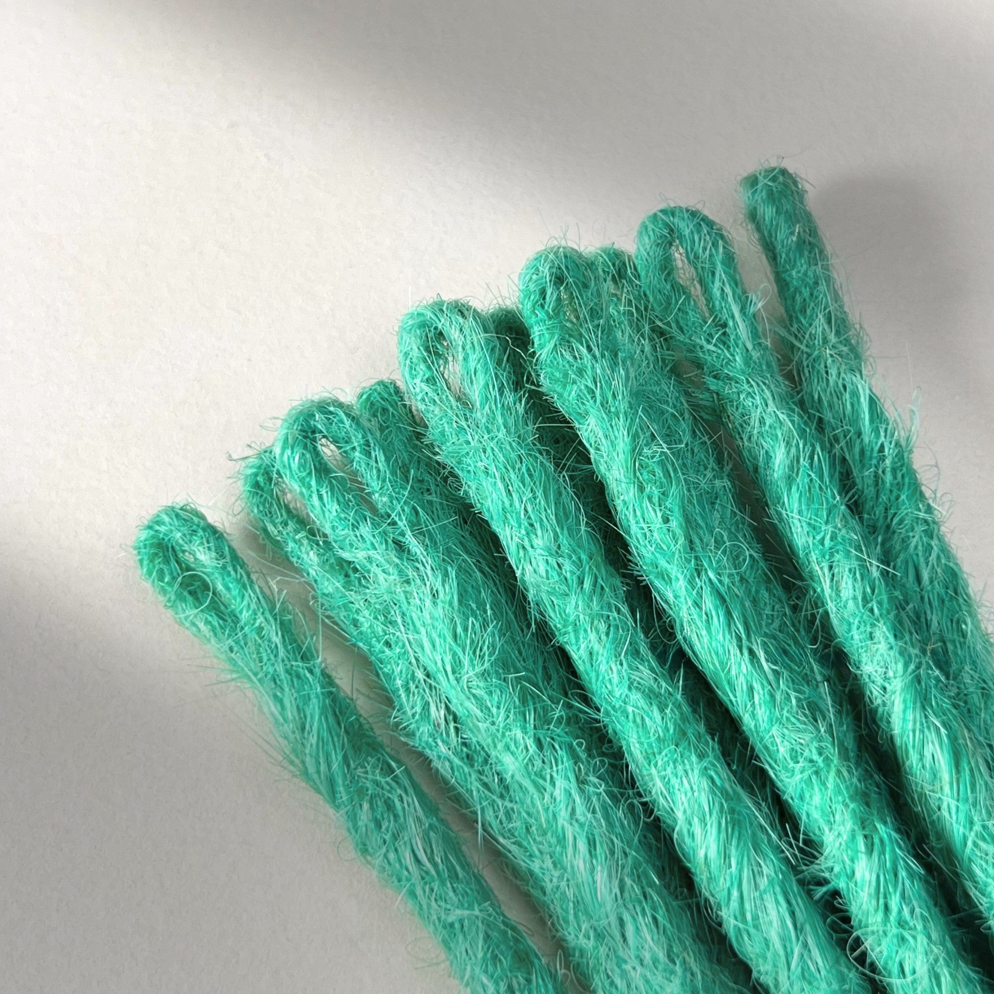 Loop detail of temporary single-ended straight loc extensions in Pastel Emerald Green.