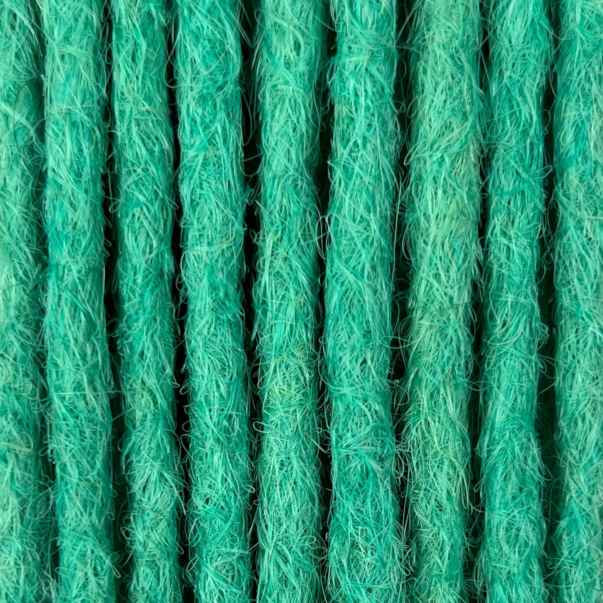 Close-up of straight loc extensions in Pastel Emerald Green, showing the texture and color.