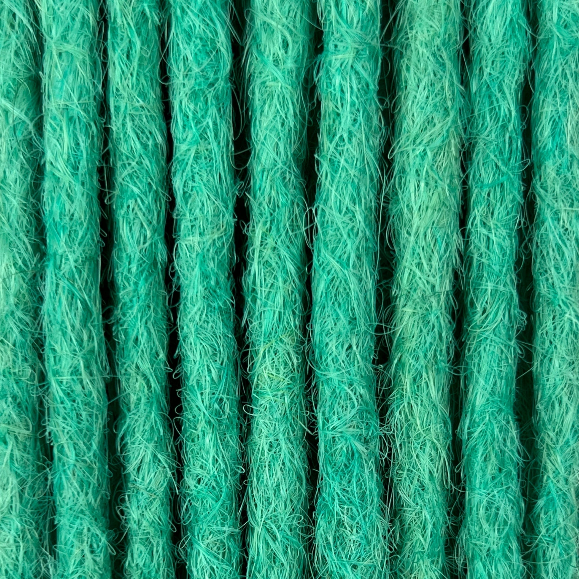 Close-up of straight loc extensions in Pastel Emerald Green, showing the texture and color.