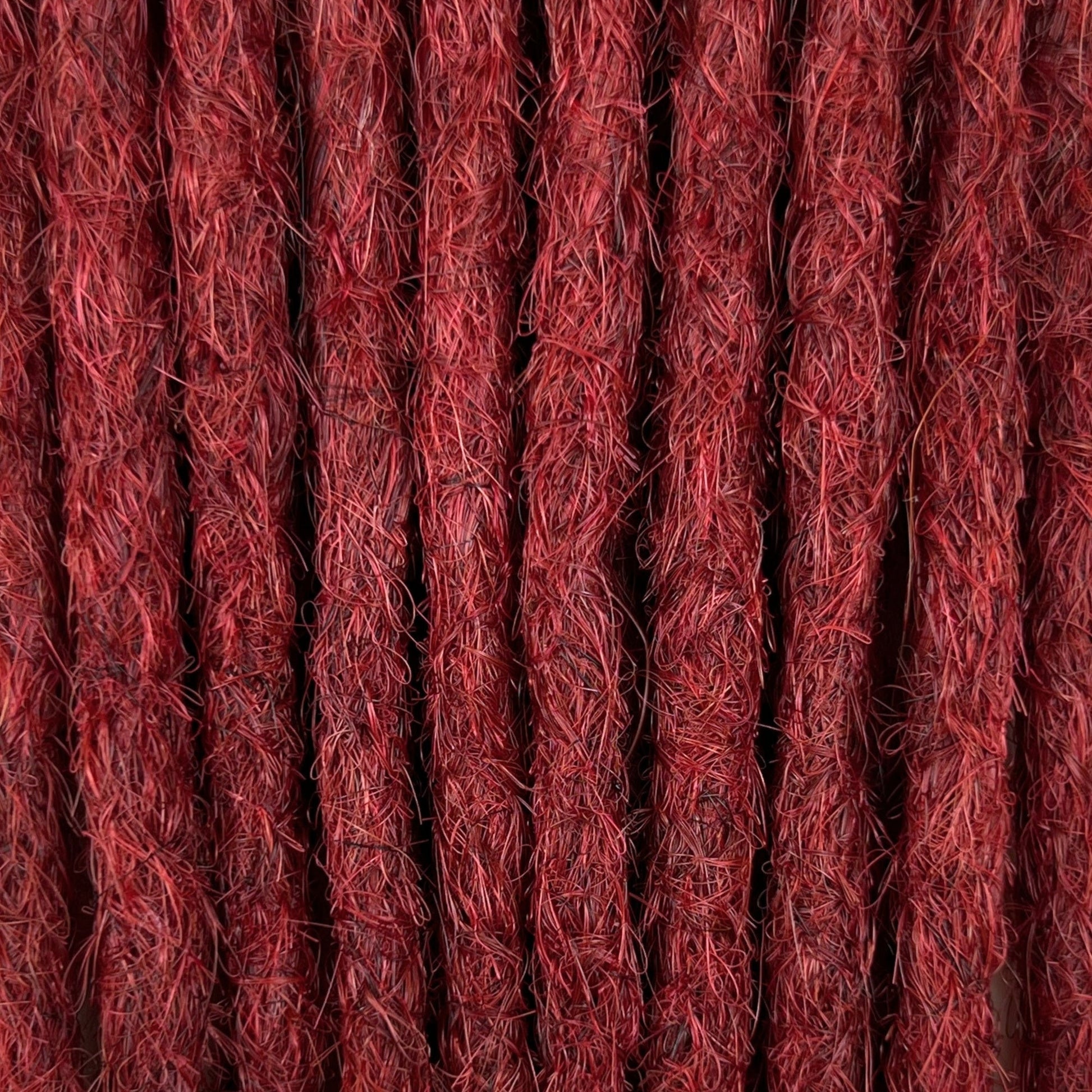 Close-up of straight loc extensions in Deep Garnet Red, showing the texture and color.