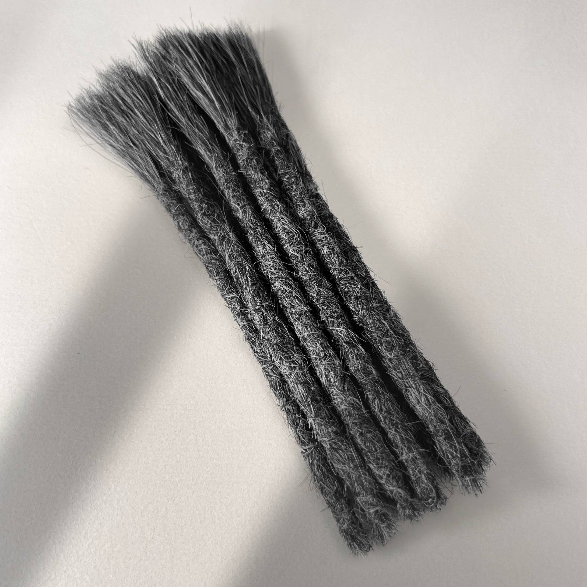 Full view of permanent straight loc extensions with blunt ends in Steel Silver.