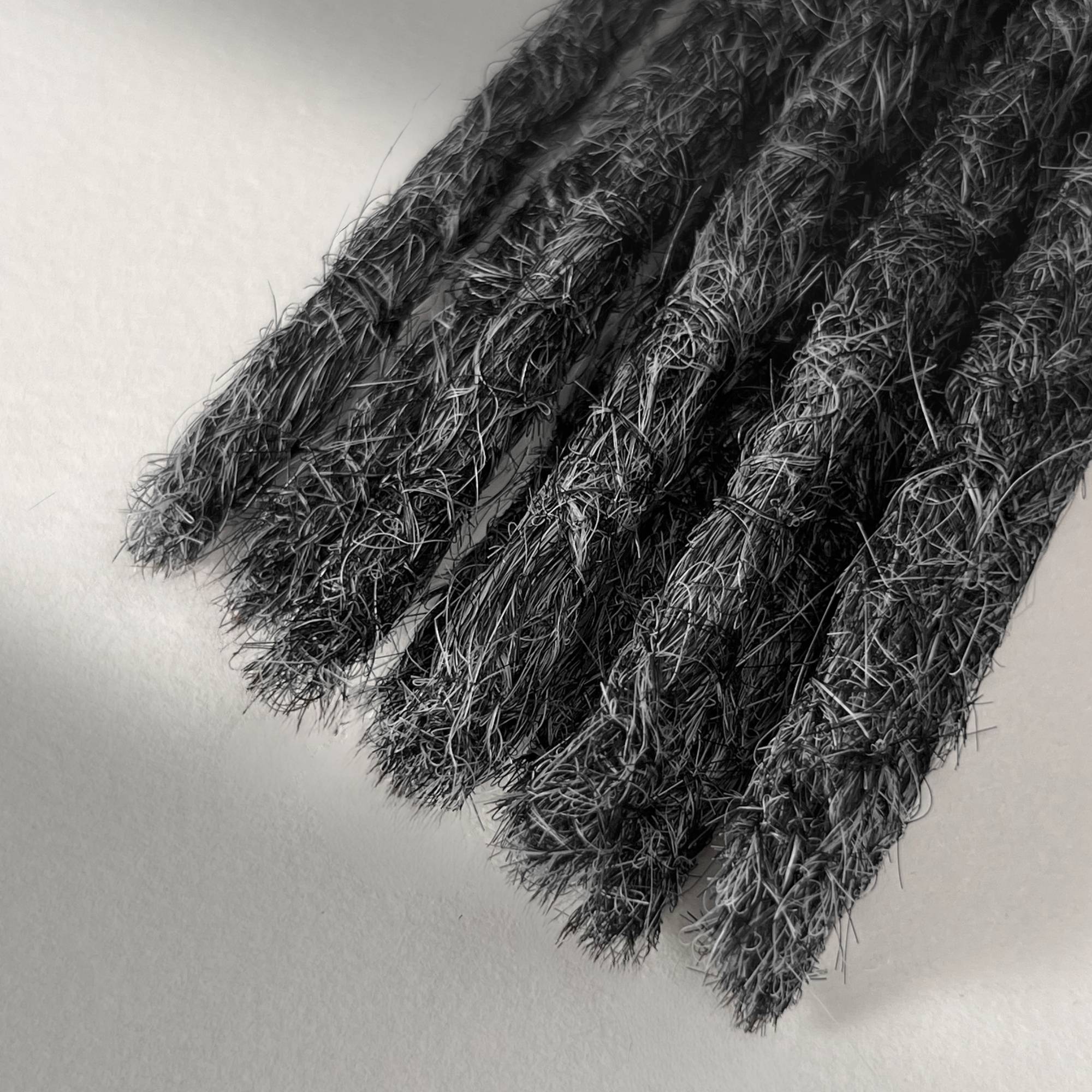 Tip detail of straight loc extensions with blunt ends in Steel Silver.