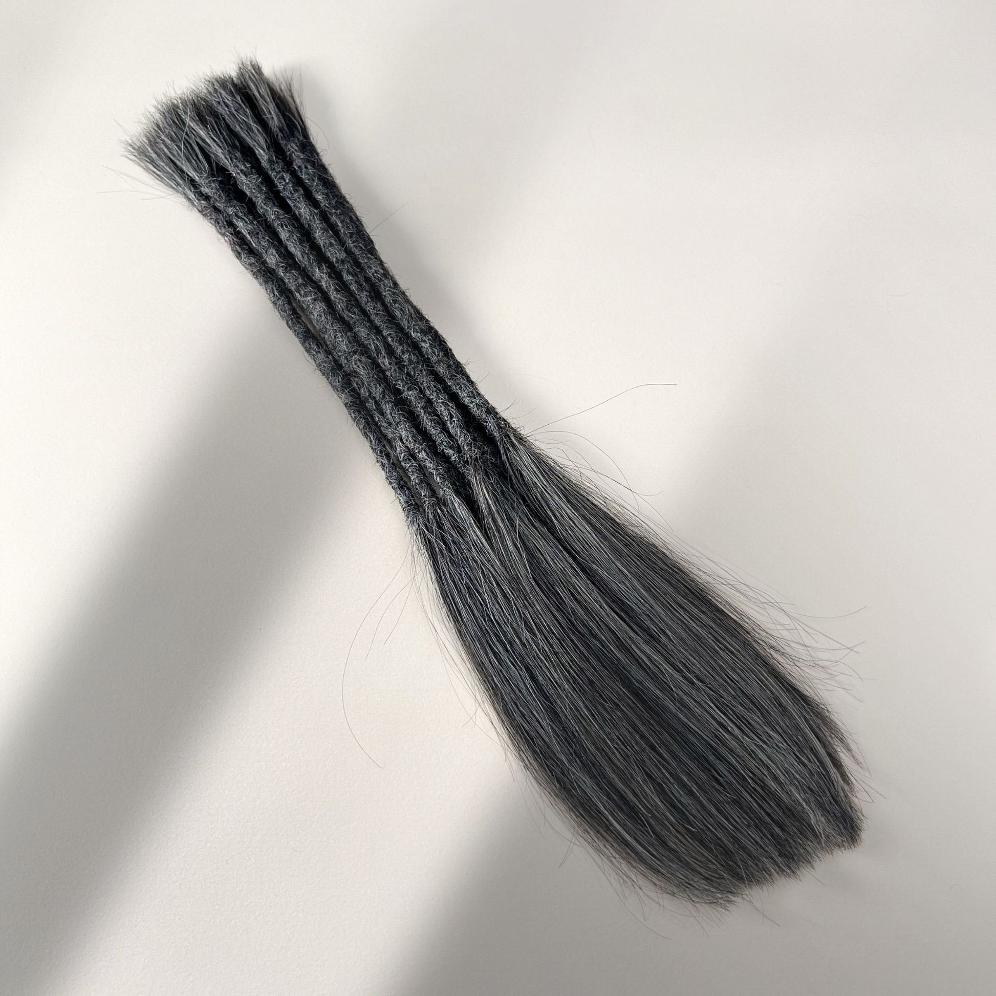 Full view of permanent straight loc extensions with long loose ends in Steel Silver.