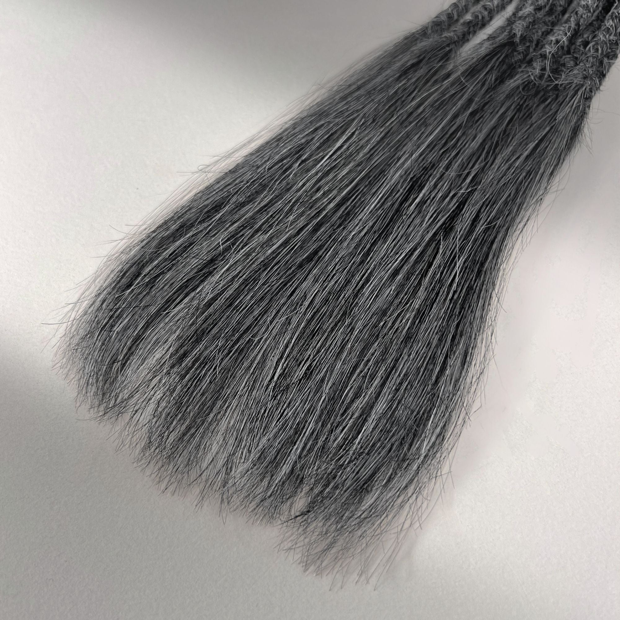 Tip detail of straight loc extensions with long loose ends in Steel Silver.