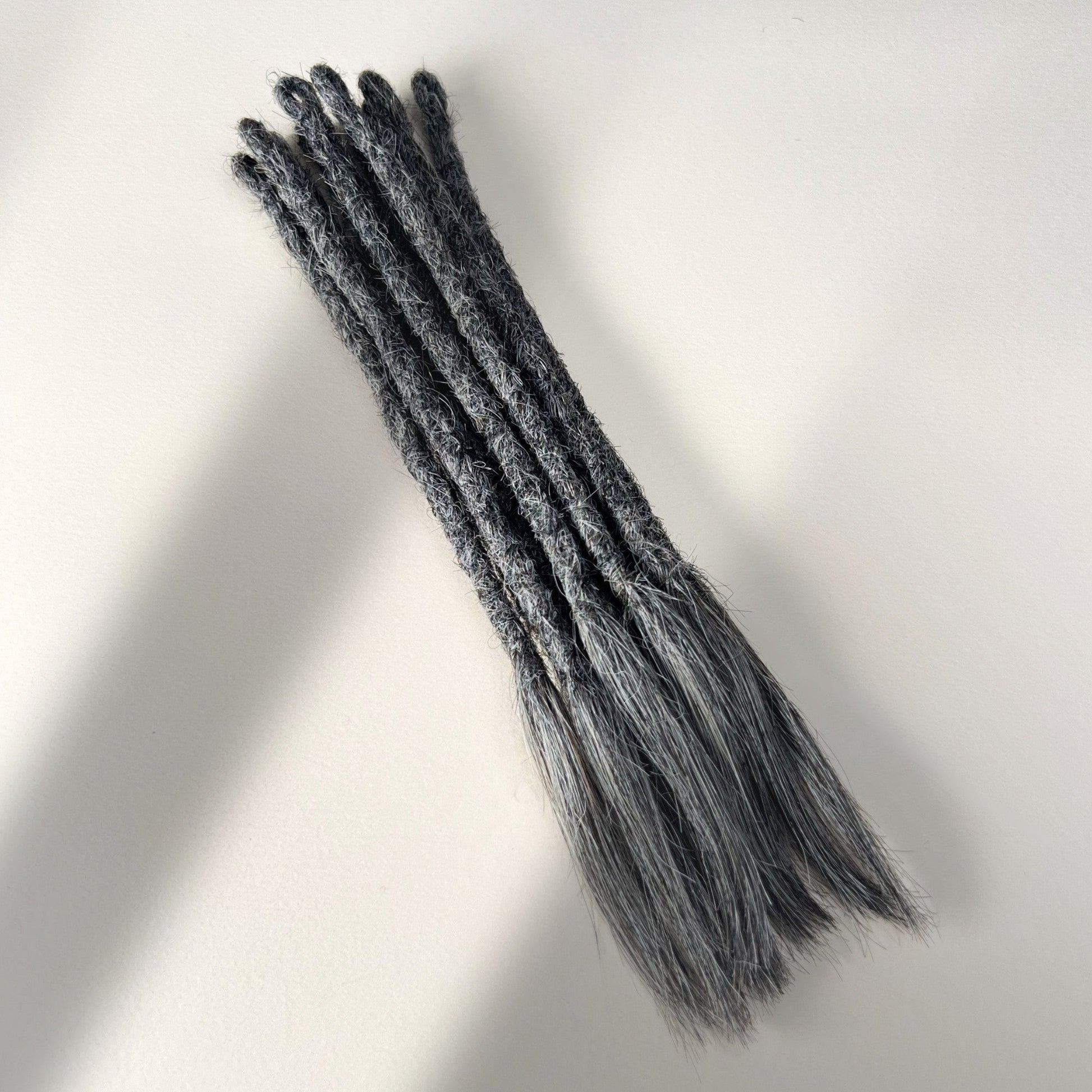 Full view of temporary single-ended straight loc extensions with open ends in Steel Silver.