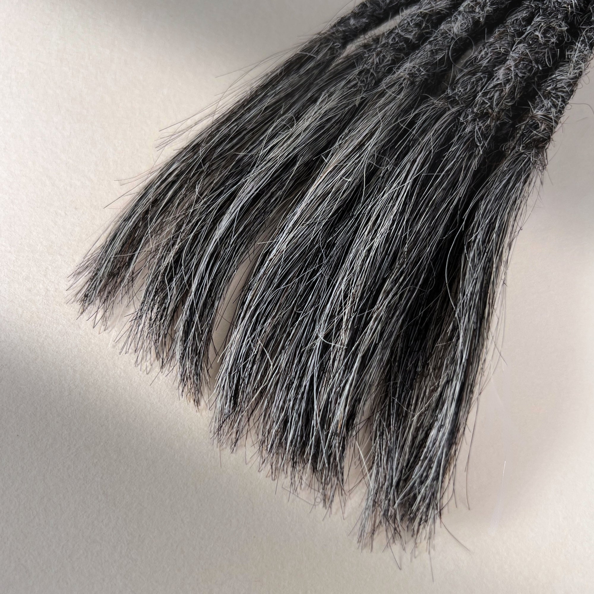 Tip detail of straight loc extensions with open ends in Steel Silver.