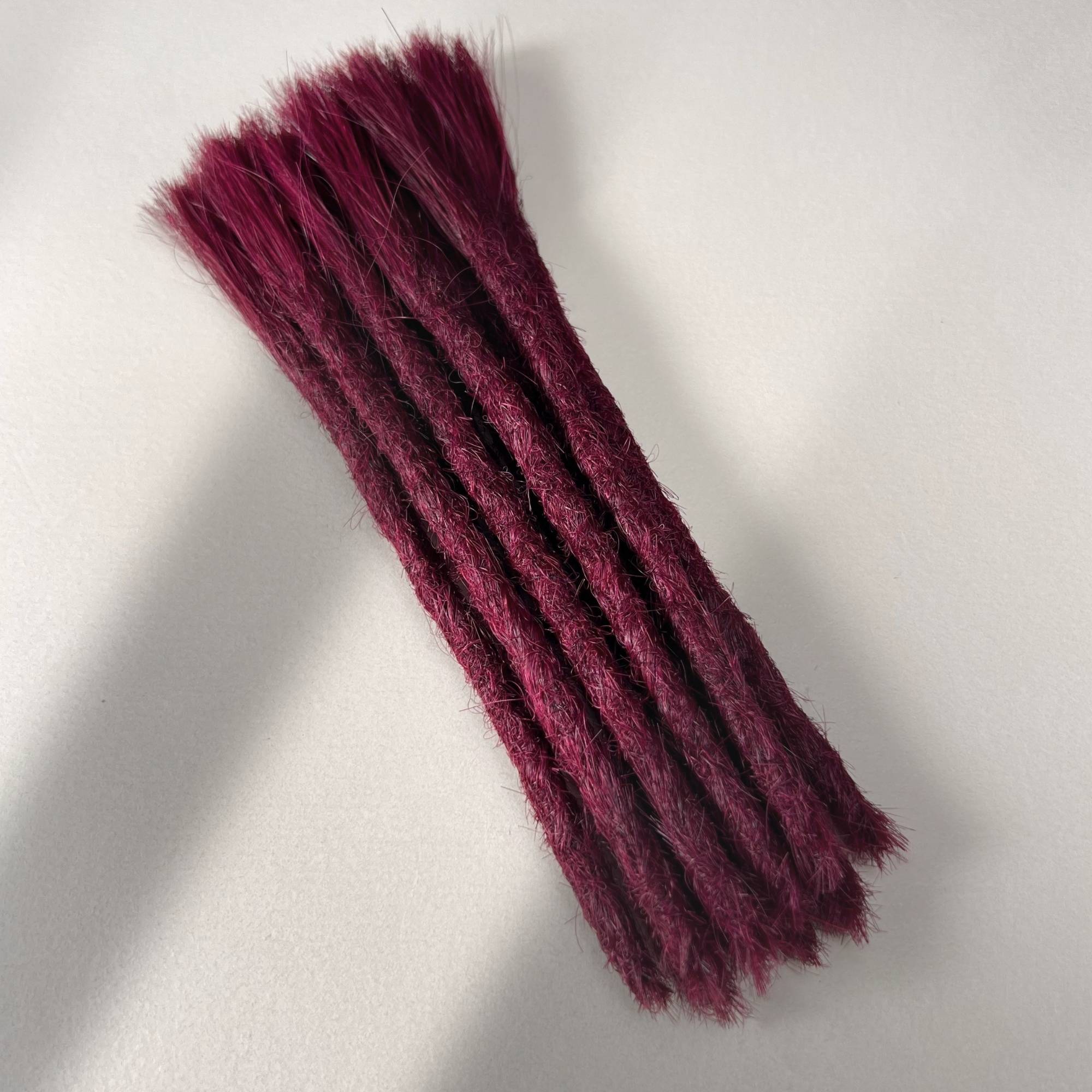 Full view of permanent straight loc extensions with blunt ends in Dark Cherry Red.