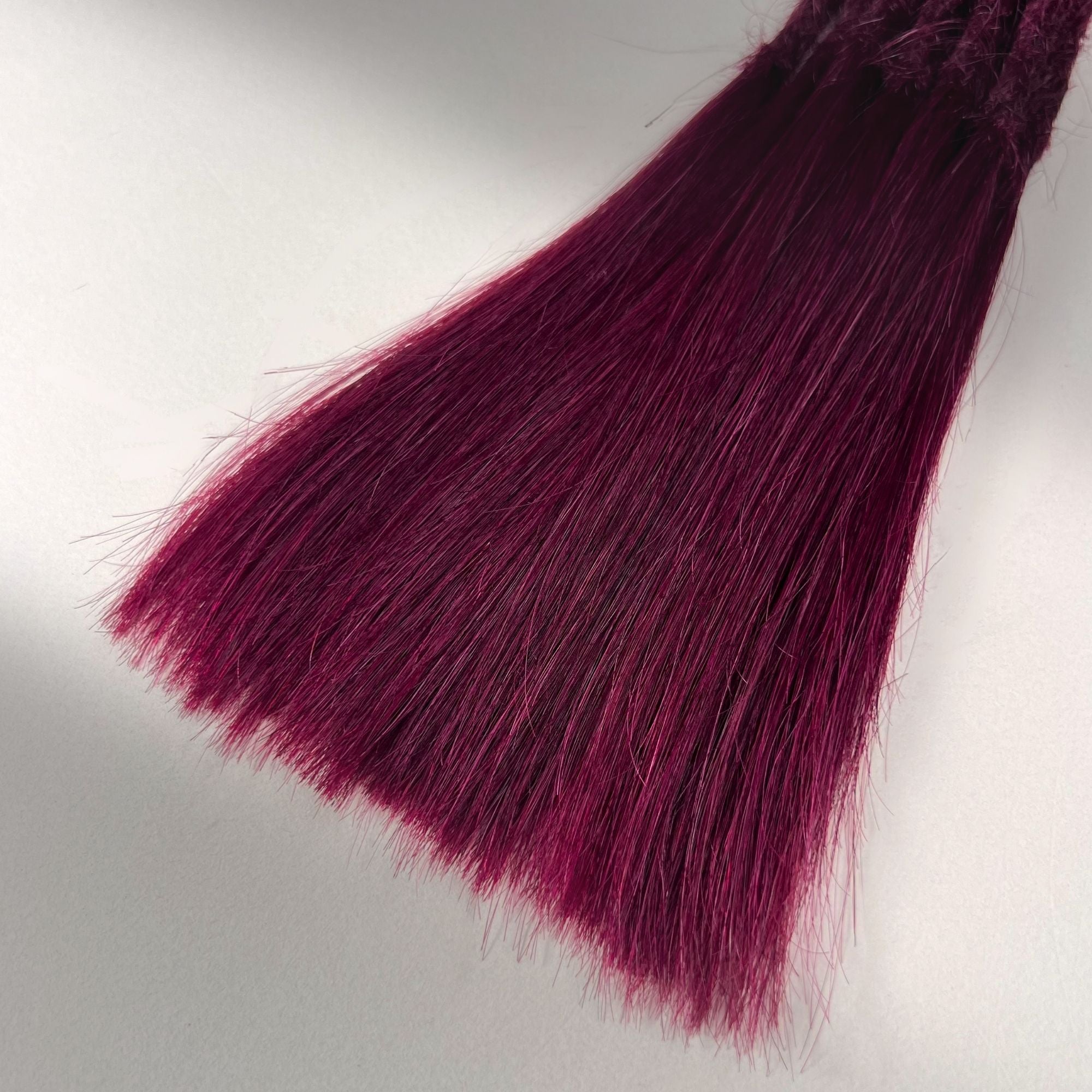 Tip detail of straight loc extensions with long loose ends in Dark Cherry Red.