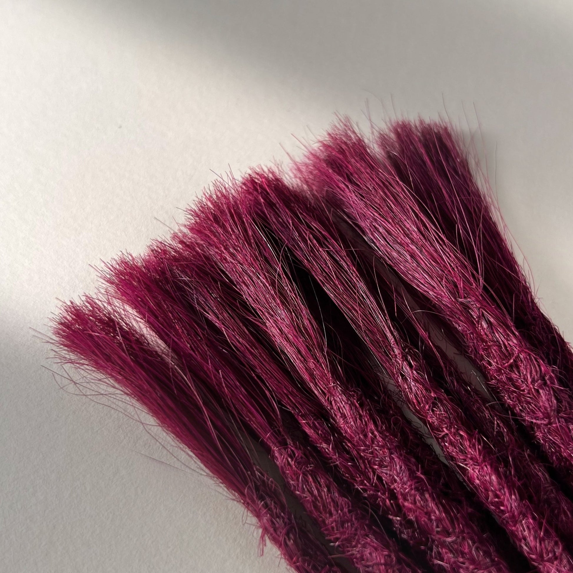 Connection point of permanent straight loc extensions in Dark Cherry Red.