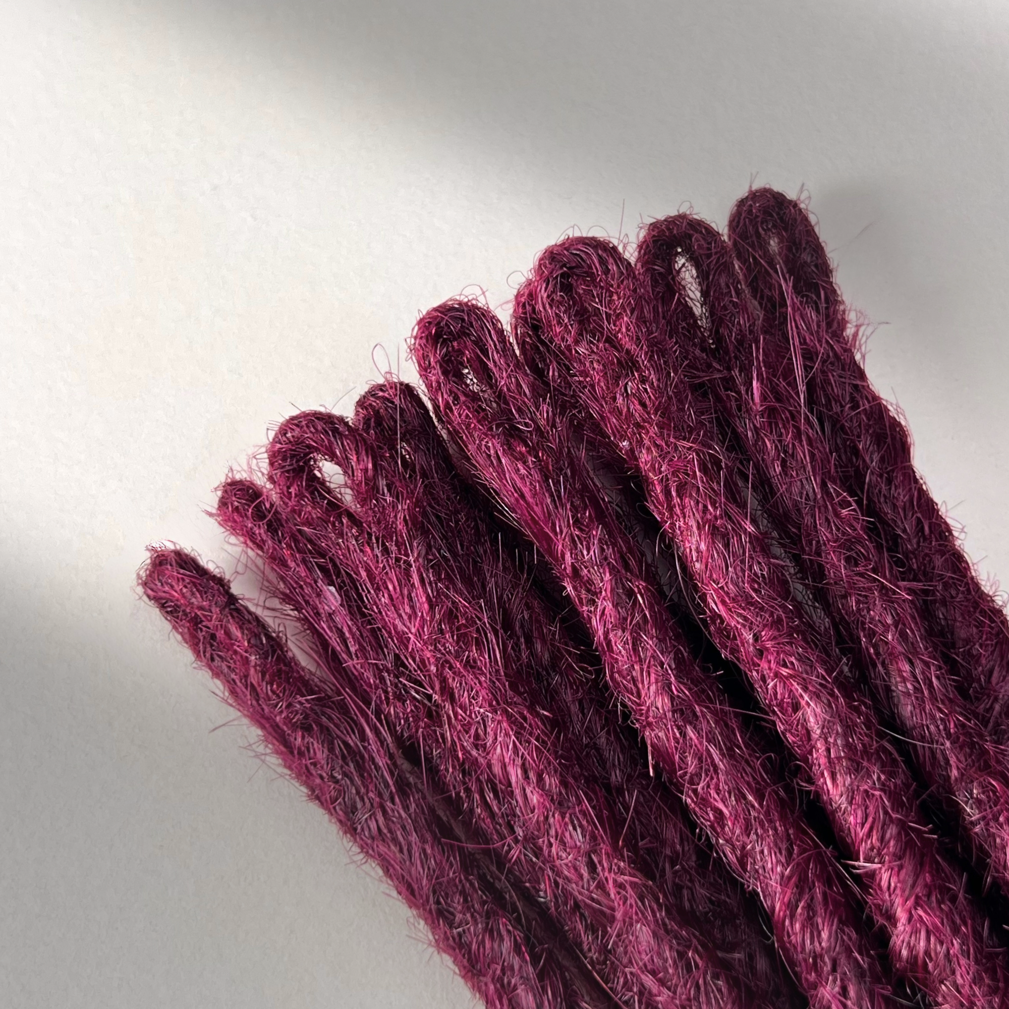 Loop detail of temporary single-ended straight loc extensions in Dark Cherry Red.