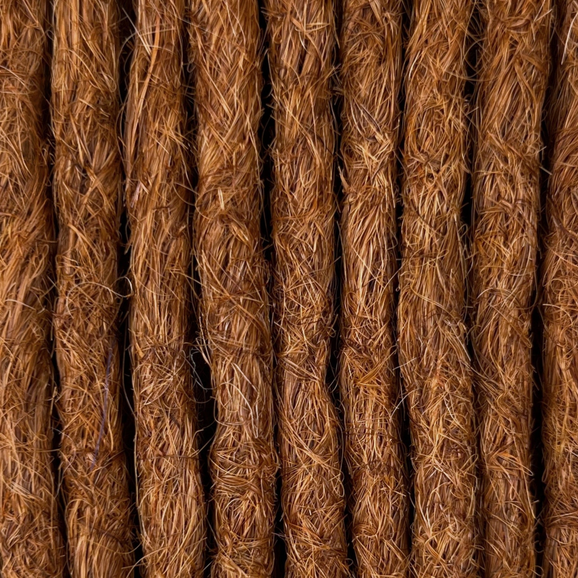 Close-up of straight loc extensions in Burnt Copper, showing the texture and color.
