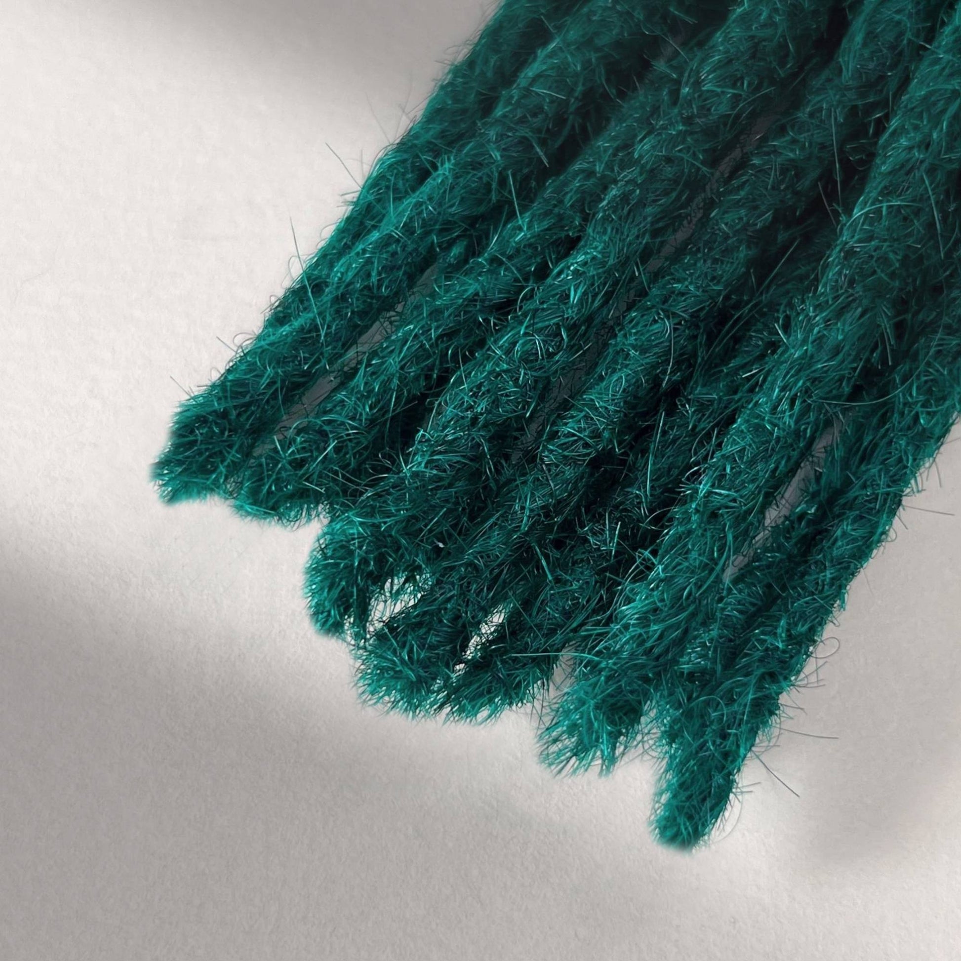 Tip detail of straight loc extensions with blunt ends in Forest Green.