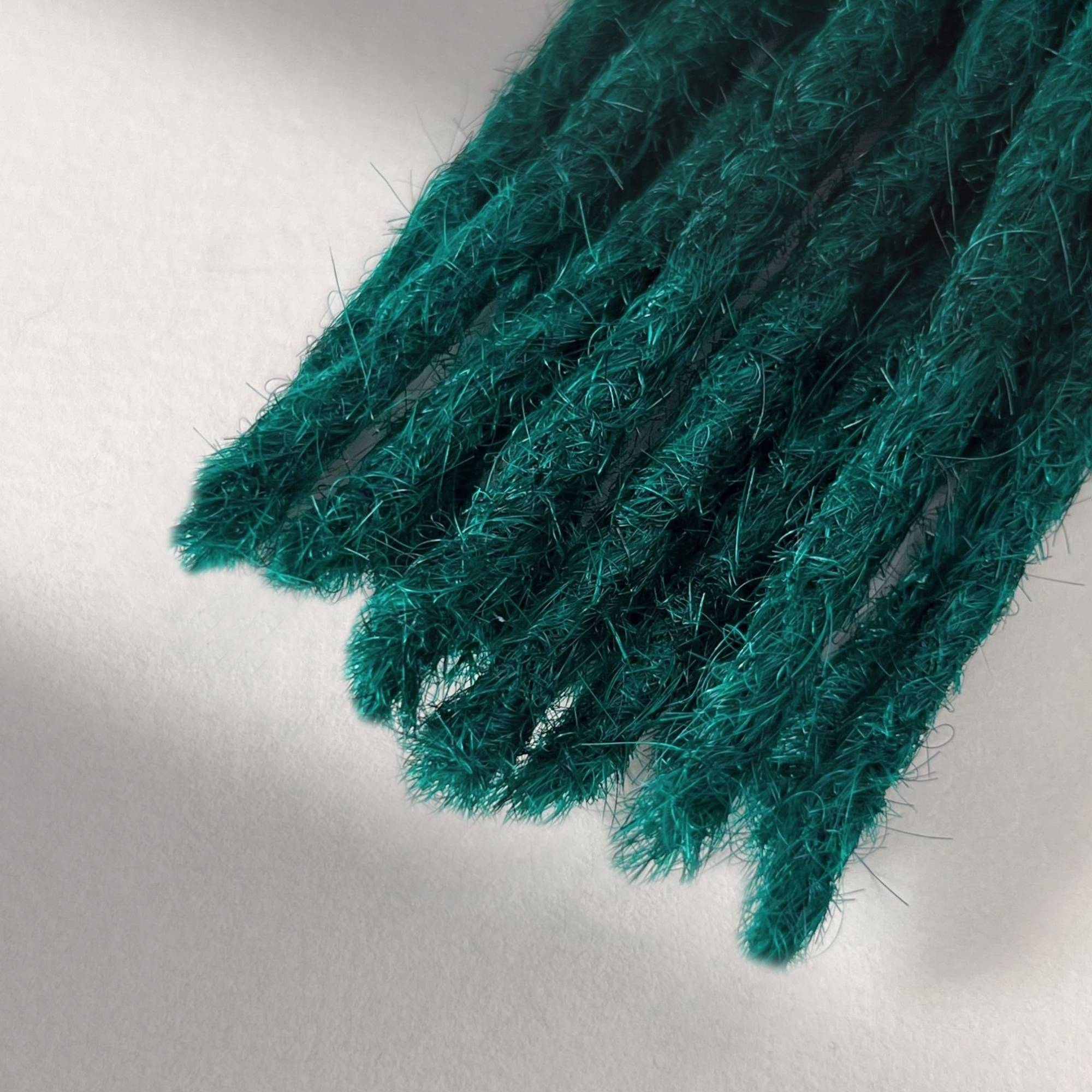 Tip detail of straight loc extensions with blunt ends in Forest Green.