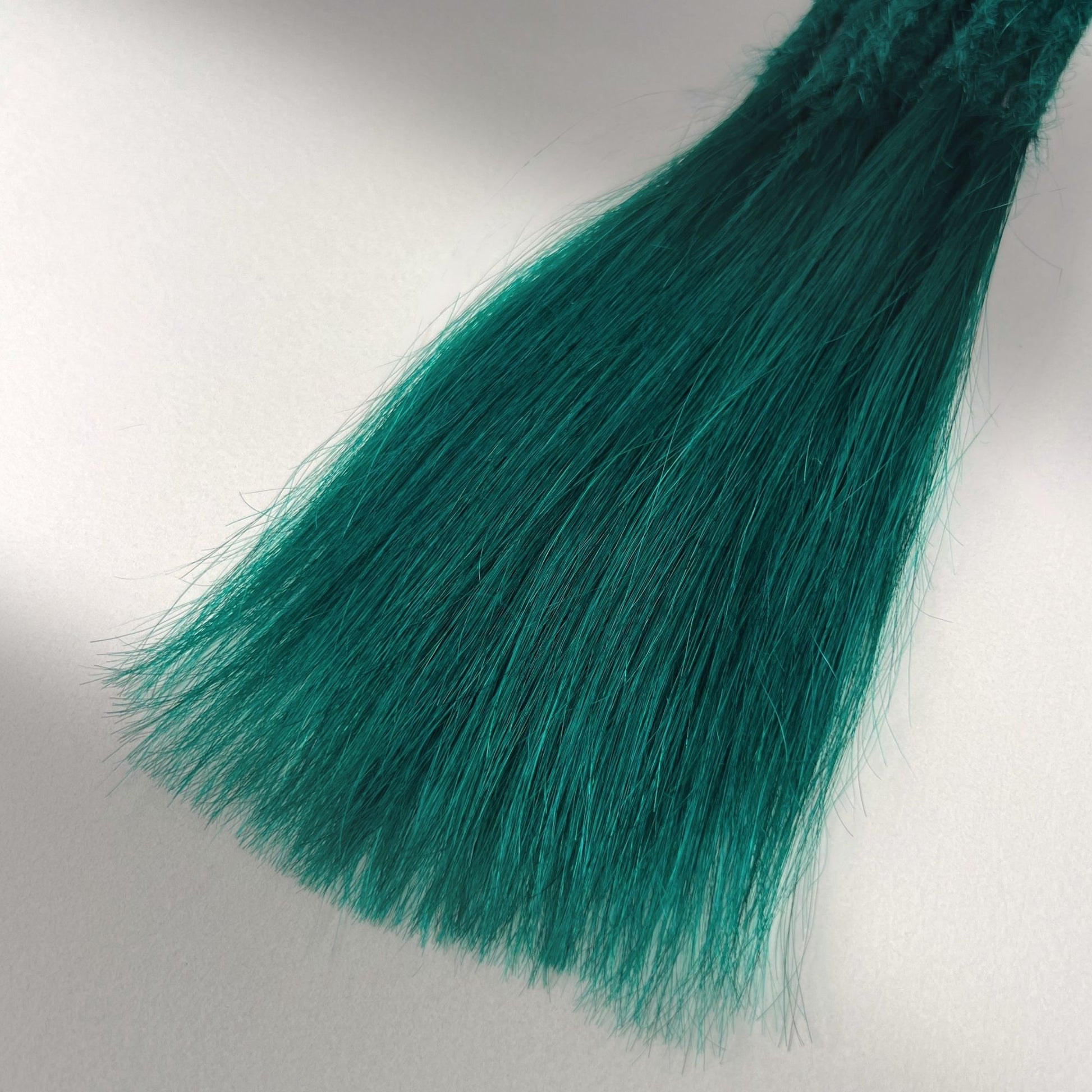 Tip detail of straight loc extensions with long loose ends in Forest Green.