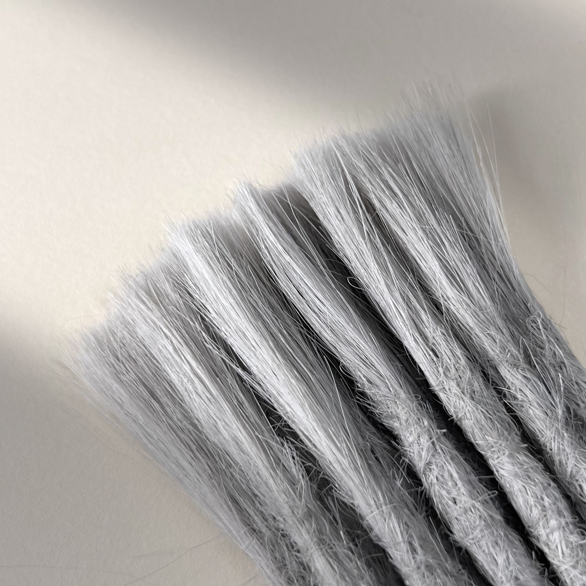 Connection point of permanent straight loc extensions with open ends in Pearl Silver.