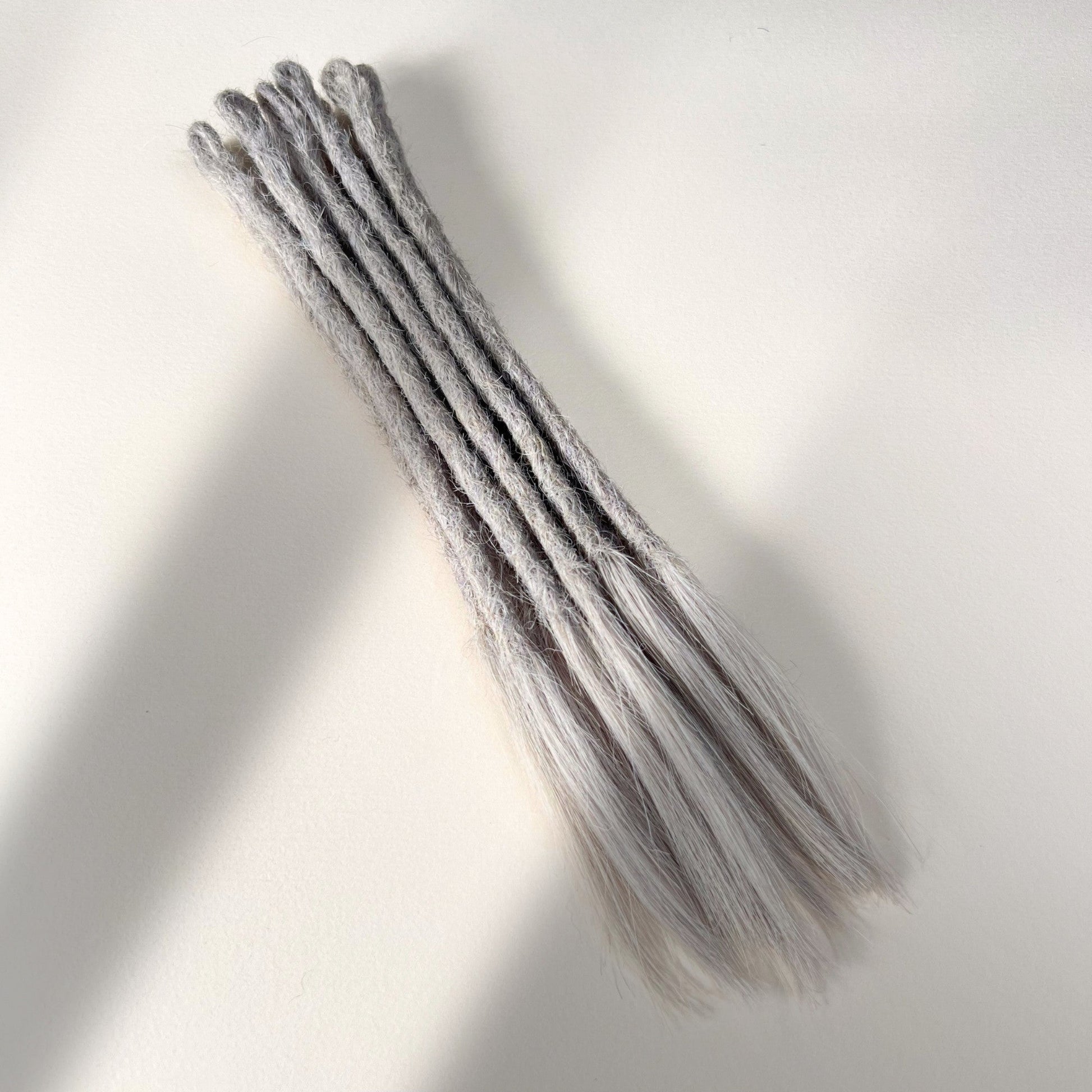 Full view of temporary single-ended straight loc extensions with open ends in Pearl Silver.
