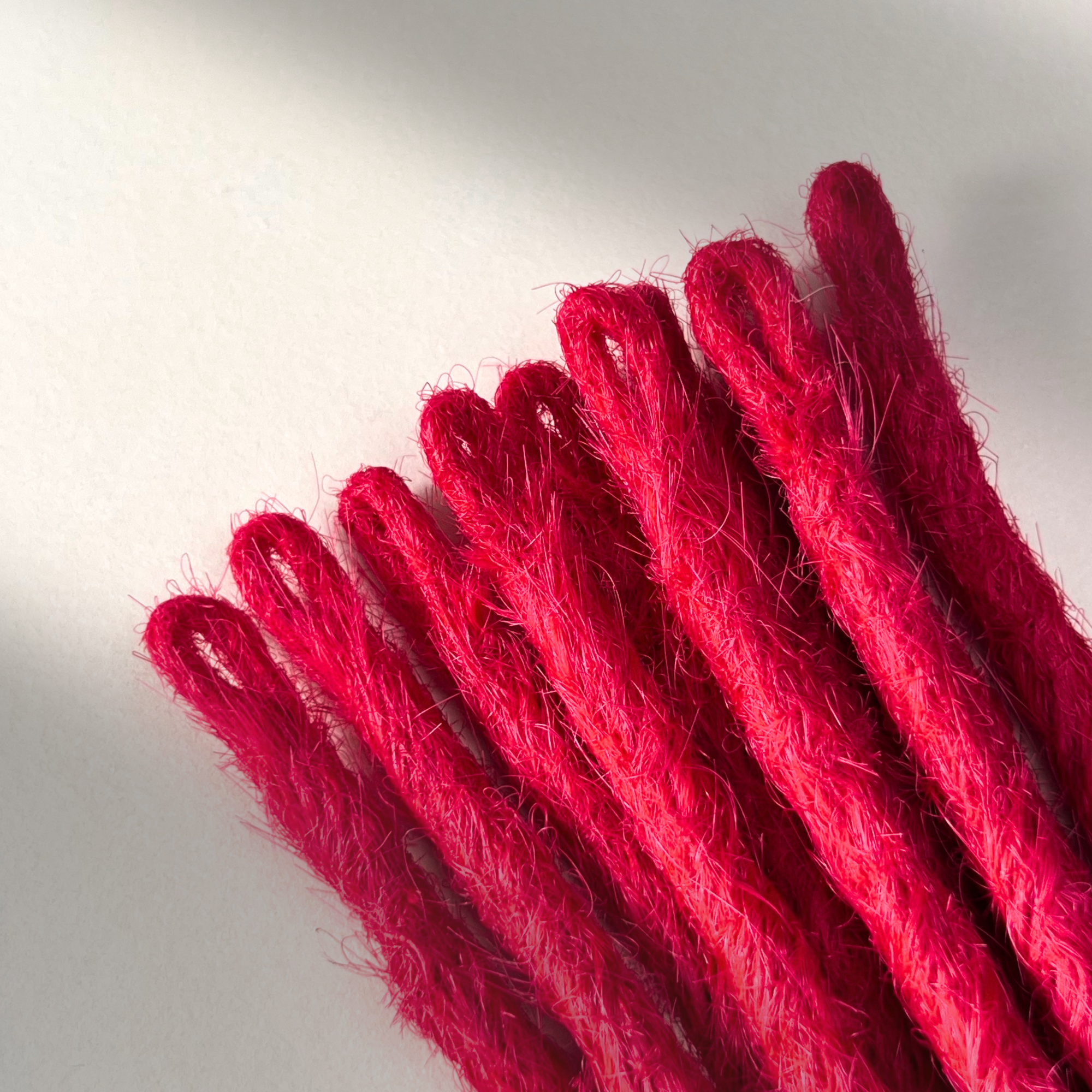 Loop detail of temporary single-ended straight loc extensions in Indian Pink.