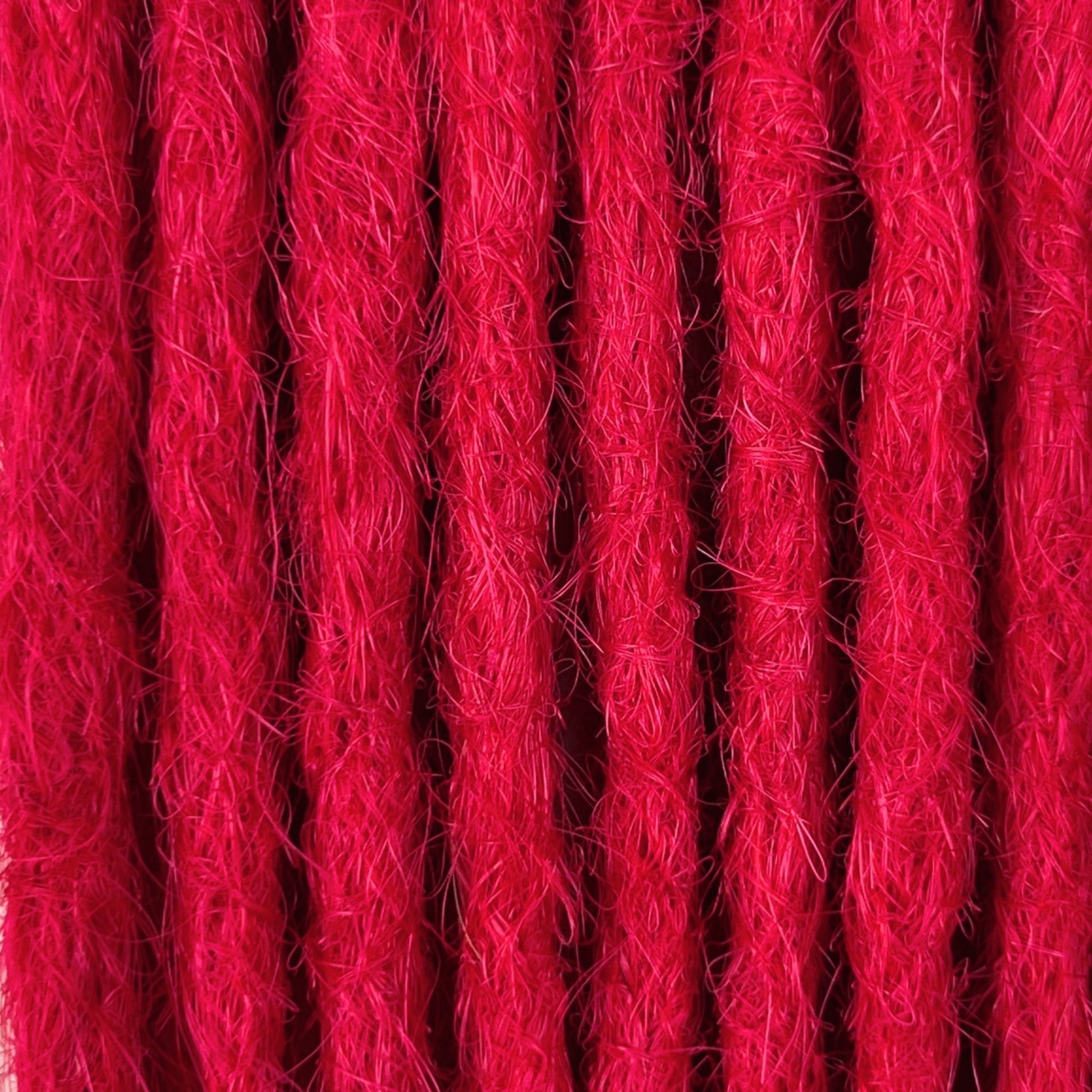 Close-up of straight loc extensions in Indian Pink, showing the texture and color.