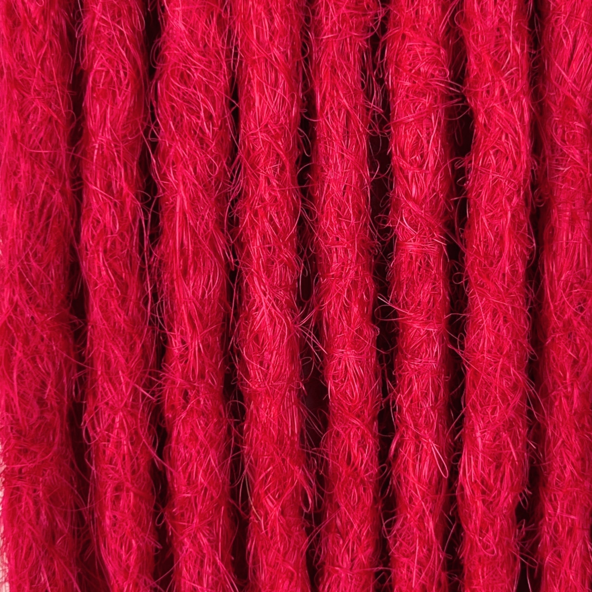 Close-up of straight loc extensions in Indian Pink, showing the texture and color.