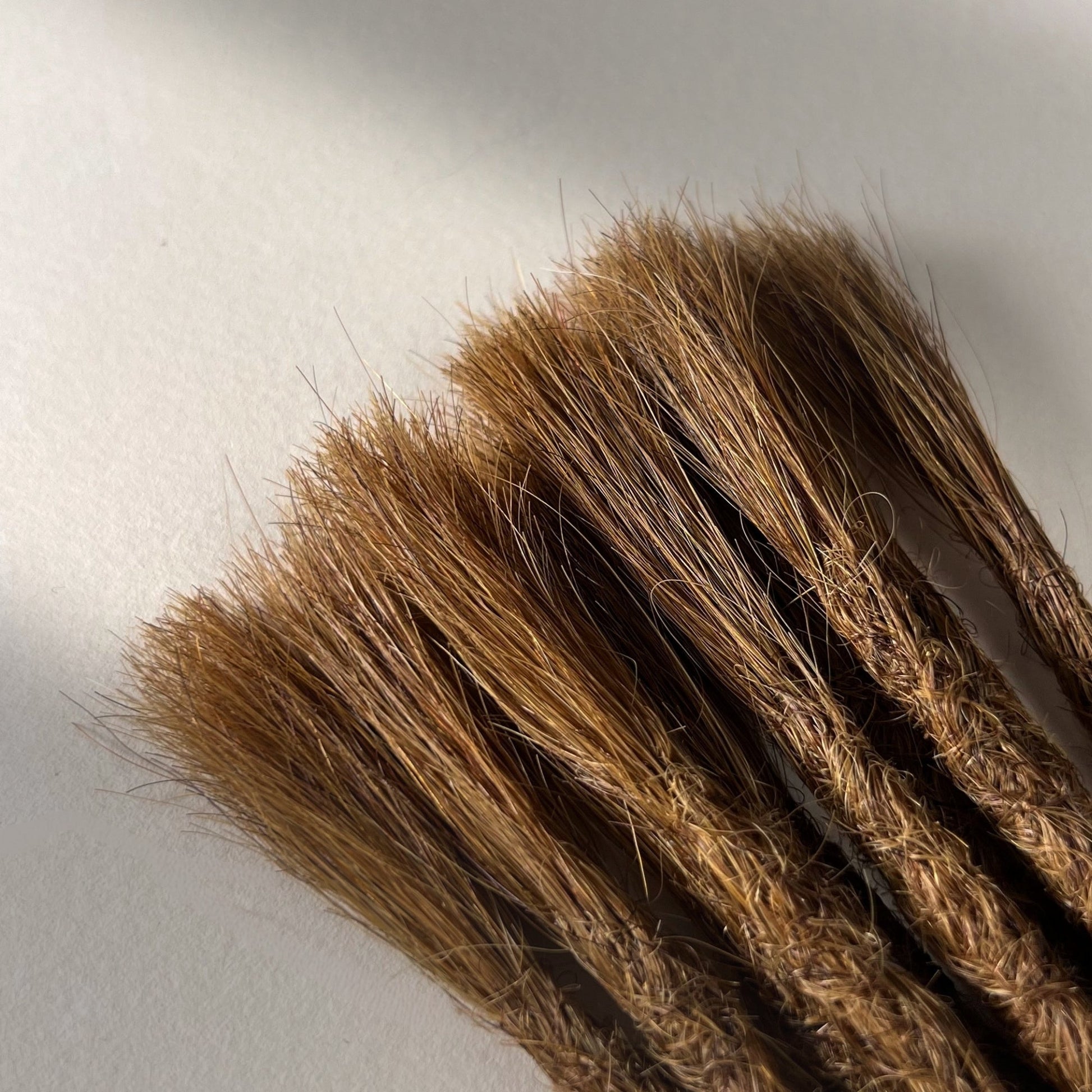Connection point of permanent straight loc extensions in Honey Brown.
