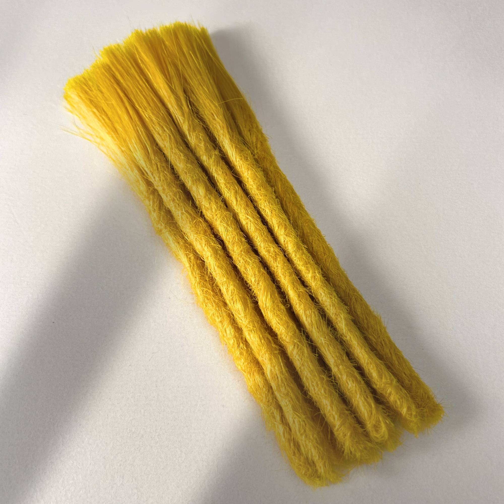 Full view of permanent straight loc extensions with blunt ends in Lemon Yellow.