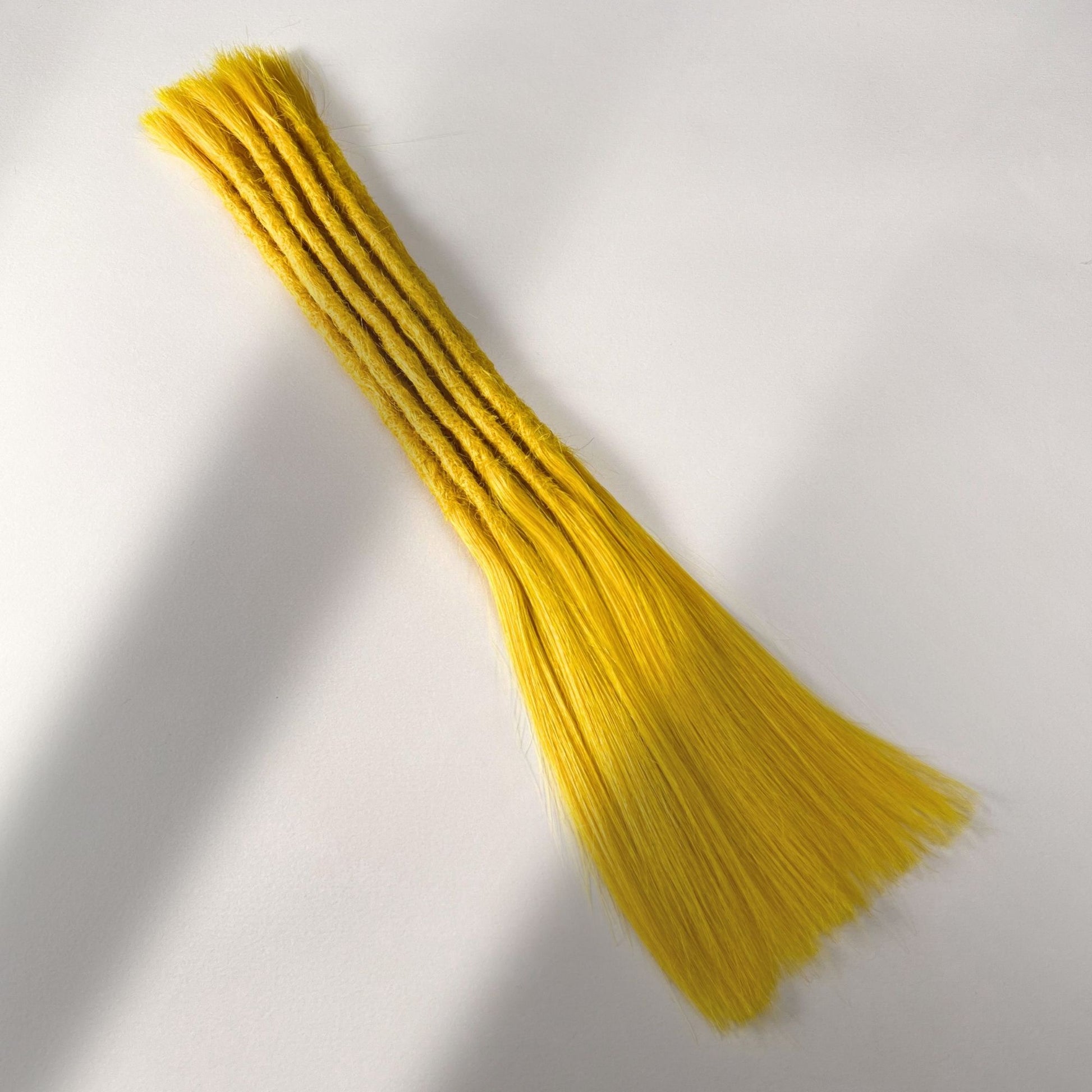 Full view of permanet straight loc extensions with long loose ends in Lemon Yellow.