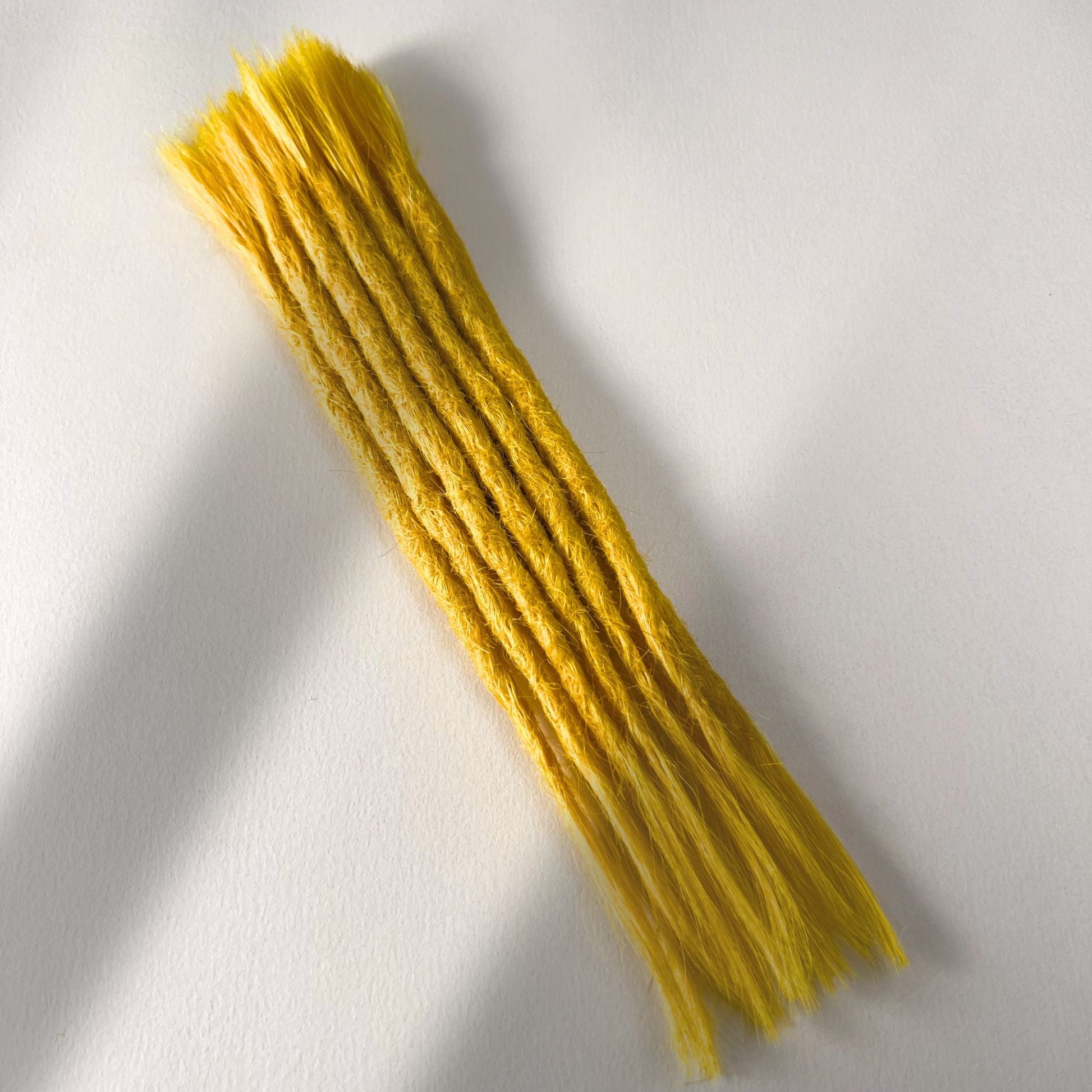 Full view of permanet straight loc extensions with open ends in Lemon Yellow.