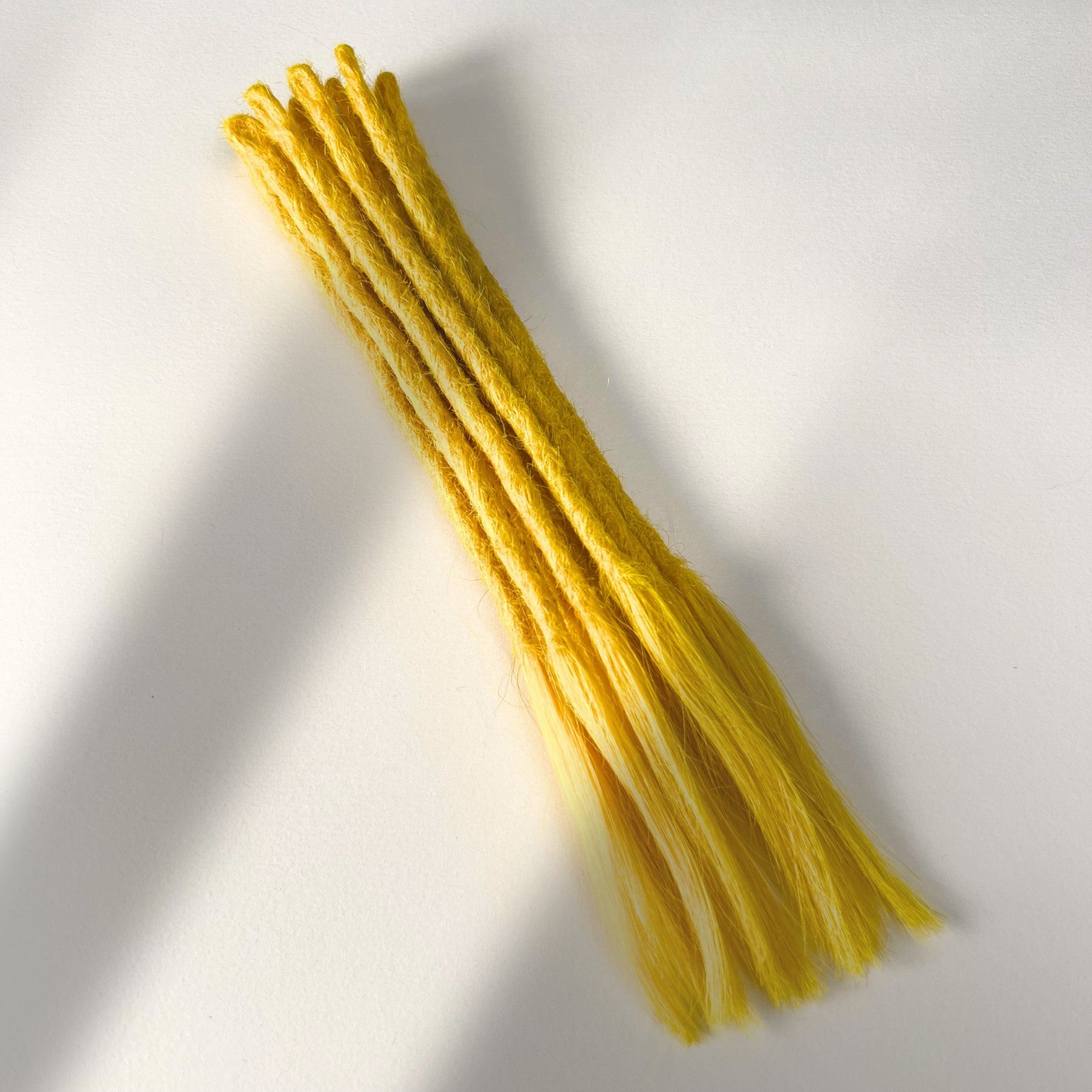 Full view of temporary single-ended straight loc extensions with open ends in Lemon Yellow.