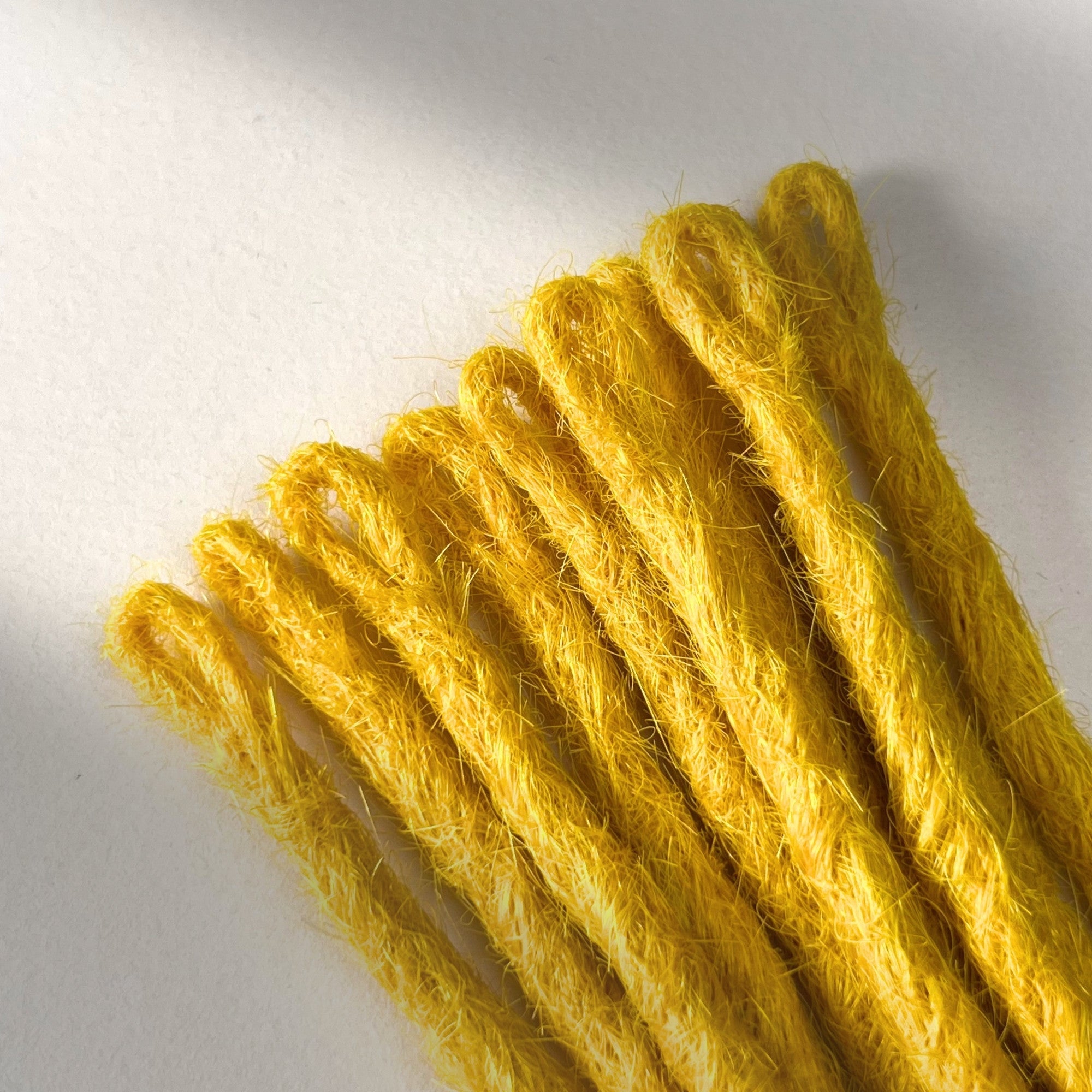 Loop detail of temporary single-ended straight loc extensions in Lemon Yellow.