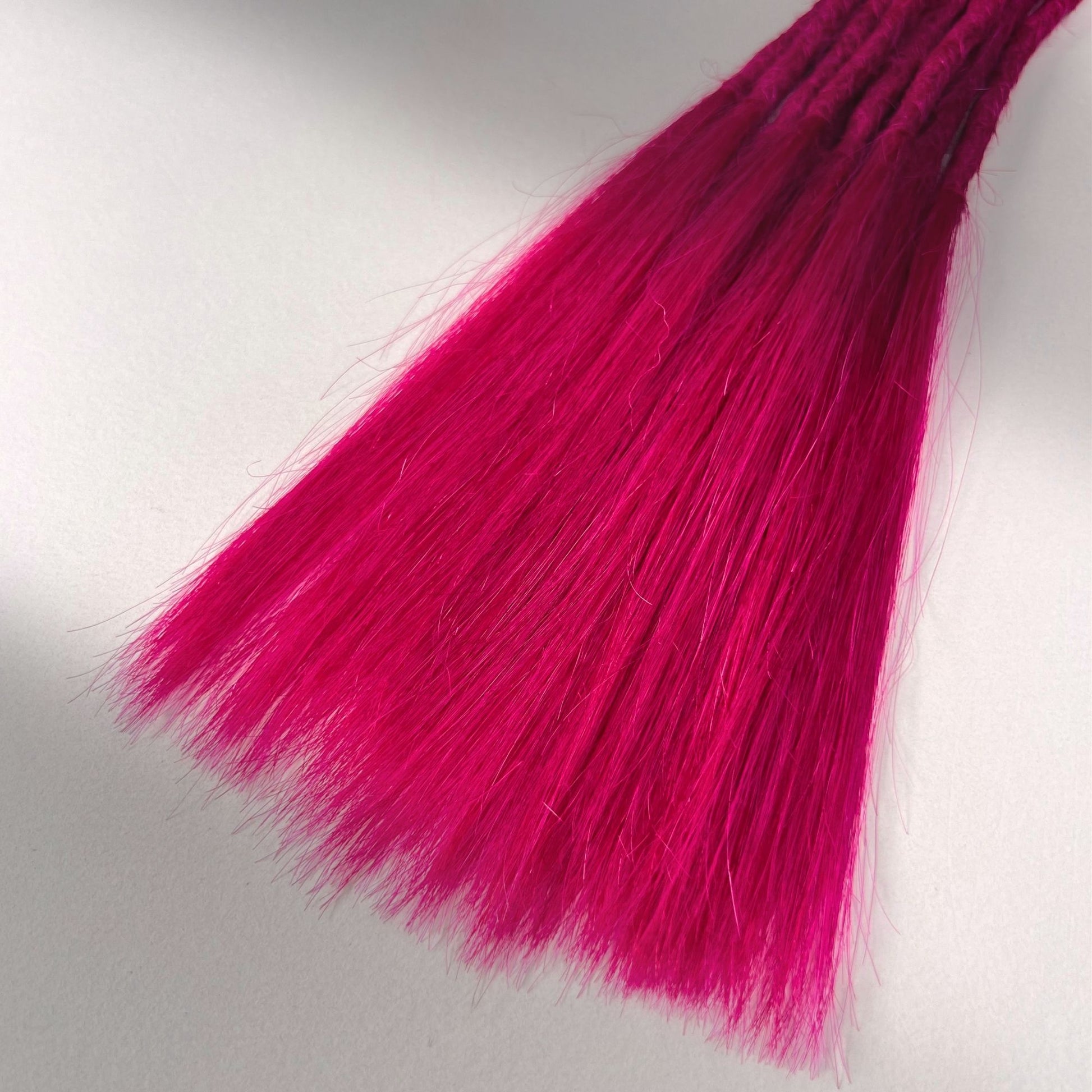 Tip detail of straight loc extensions with long loose ends in Magenta Pink.