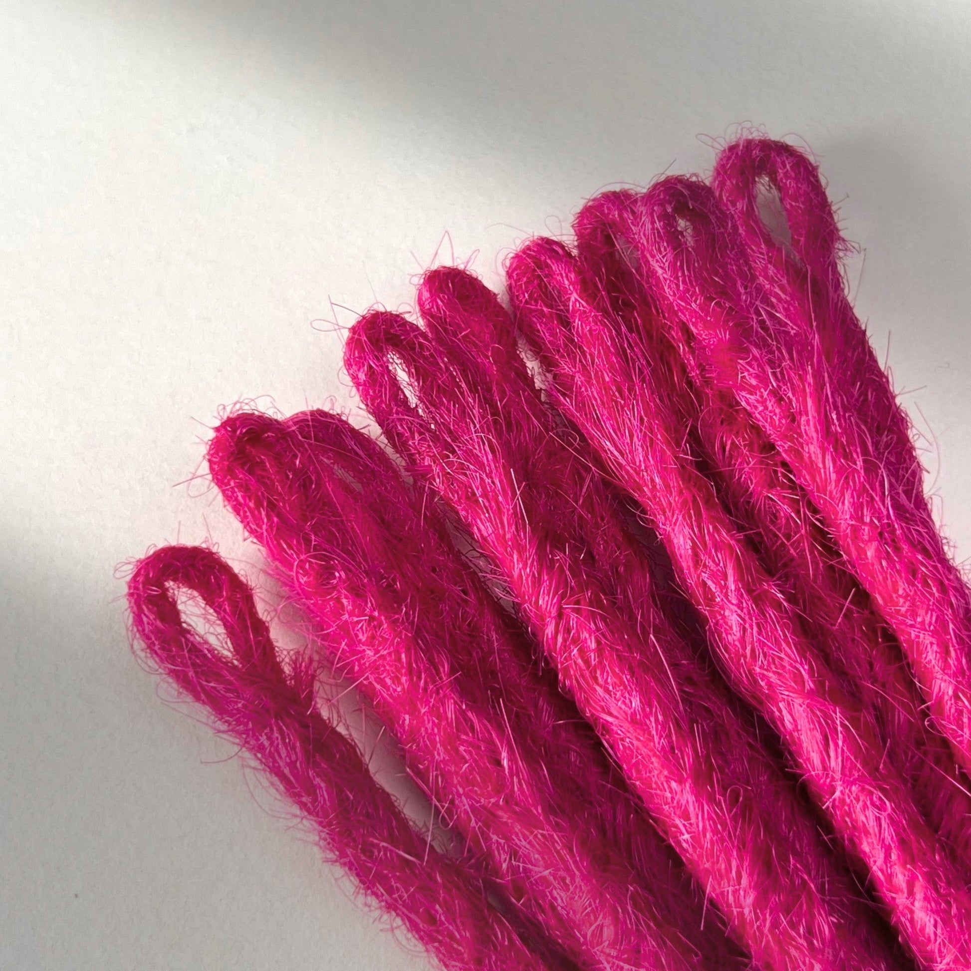 Loop detail of temporary single-ended straight loc extensions in Magenta Pink.