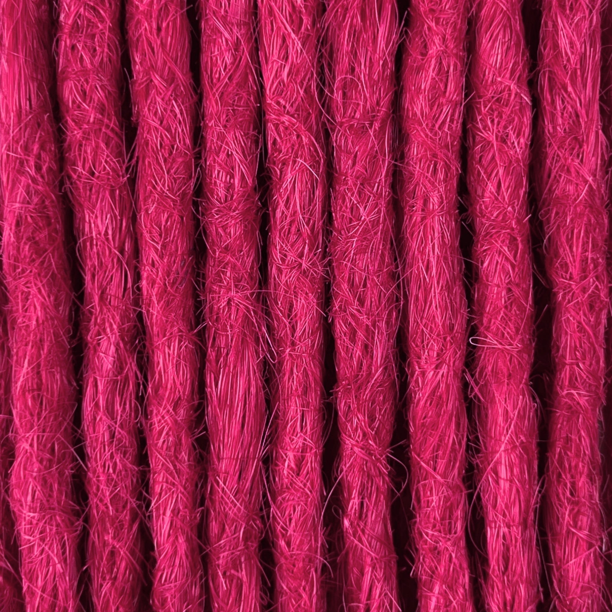 Close-up of straight loc extensions in Magenta Pink, showing the texture and color.