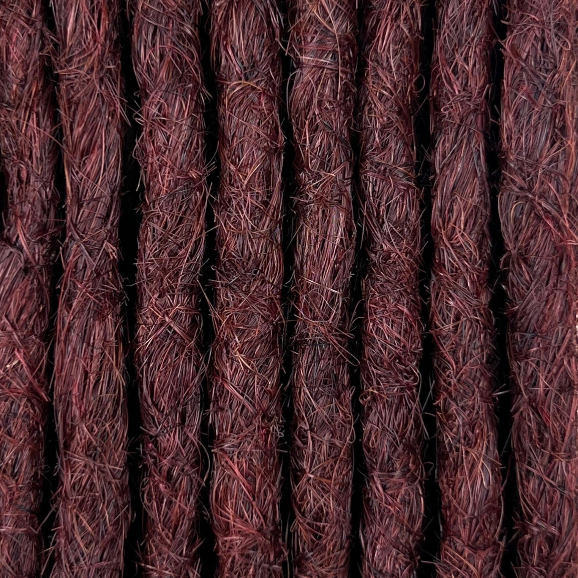 Close-up of straight loc extensions in Warm Mahogany Red, showing the texture and color.