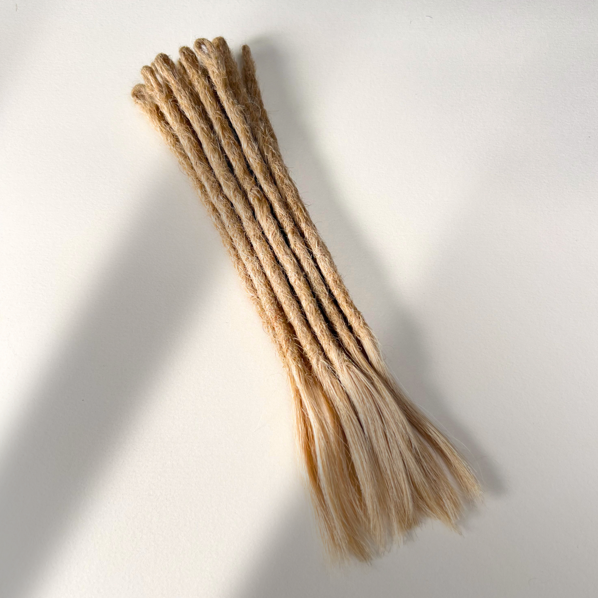 Full view of temporary single-ended straight loc extensions with open ends in Vanilla Blonde.
