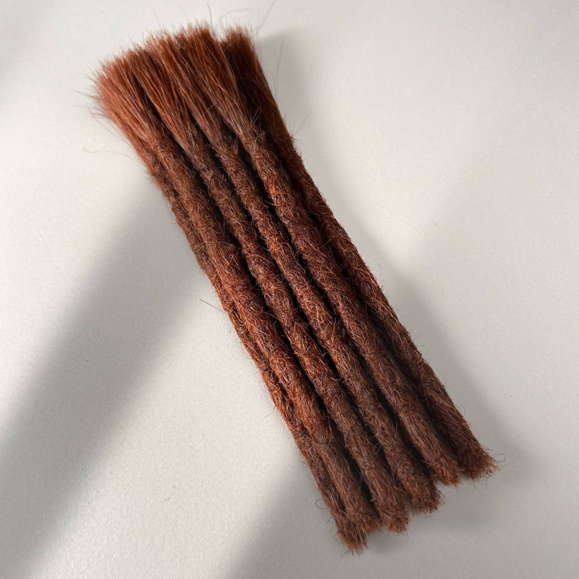 Full view of permanent straight loc extensions with blunt ends in Warm Maple Copper.