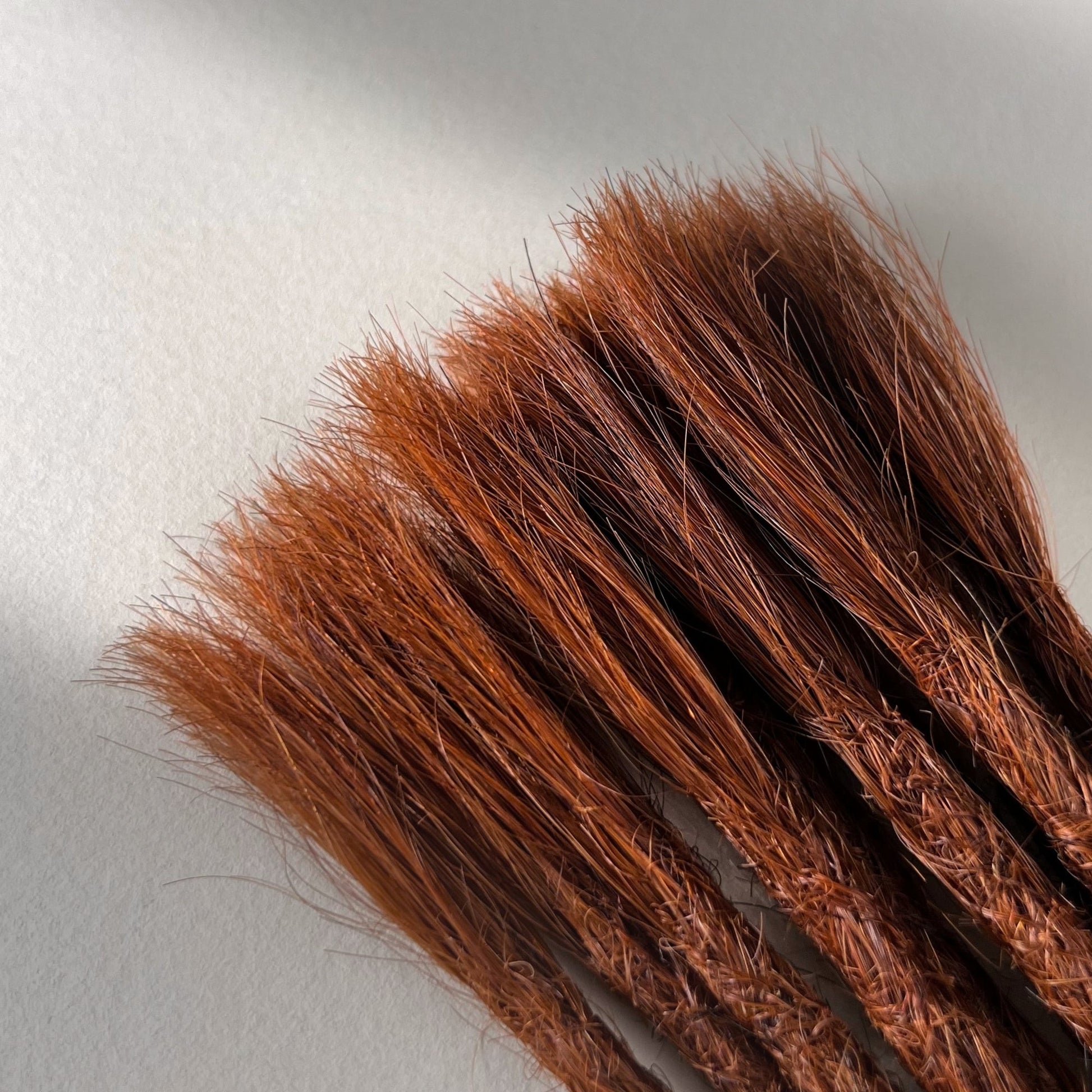 Connection point of permanent straight loc extensions in Warm Maple Copper.